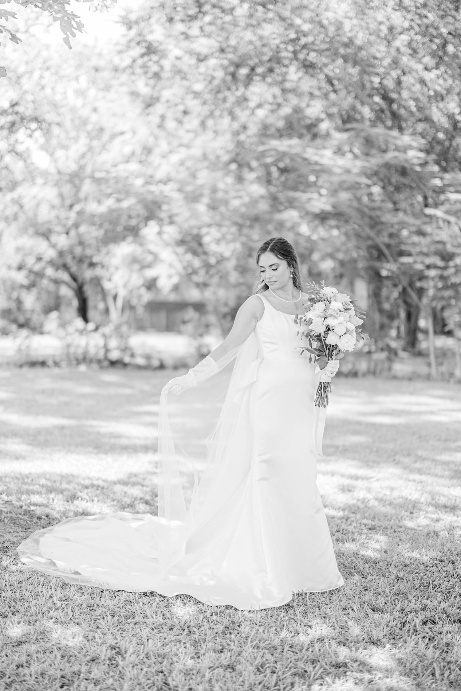Ethereal black and white bridal portraits in a sunlit garden setting.