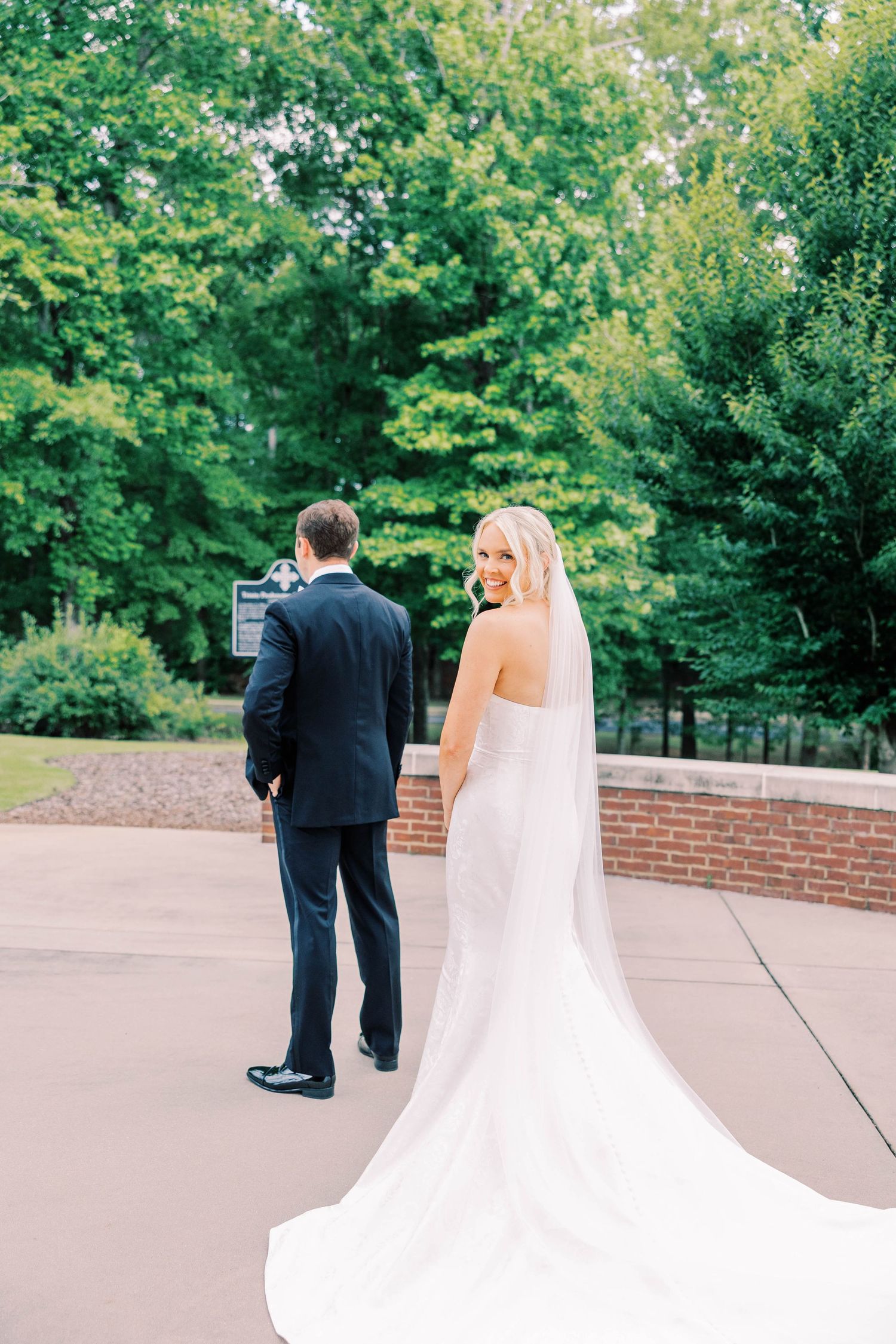 Sequence showing couple's first look moment outdoors with flowing wedding dress and veil.