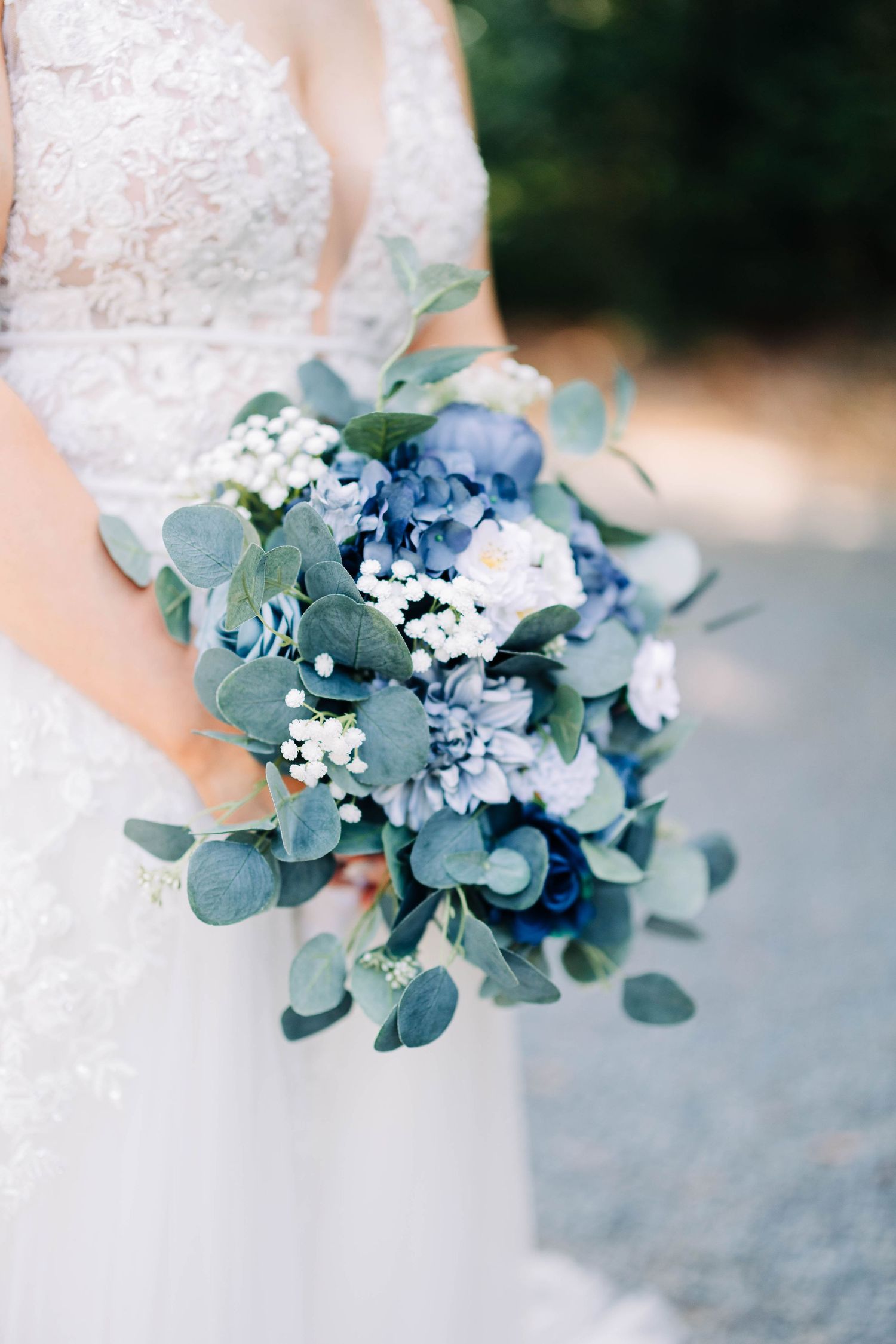 Delicate blue and white wedding bouquet with eucalyptus leaves and baby's breath.