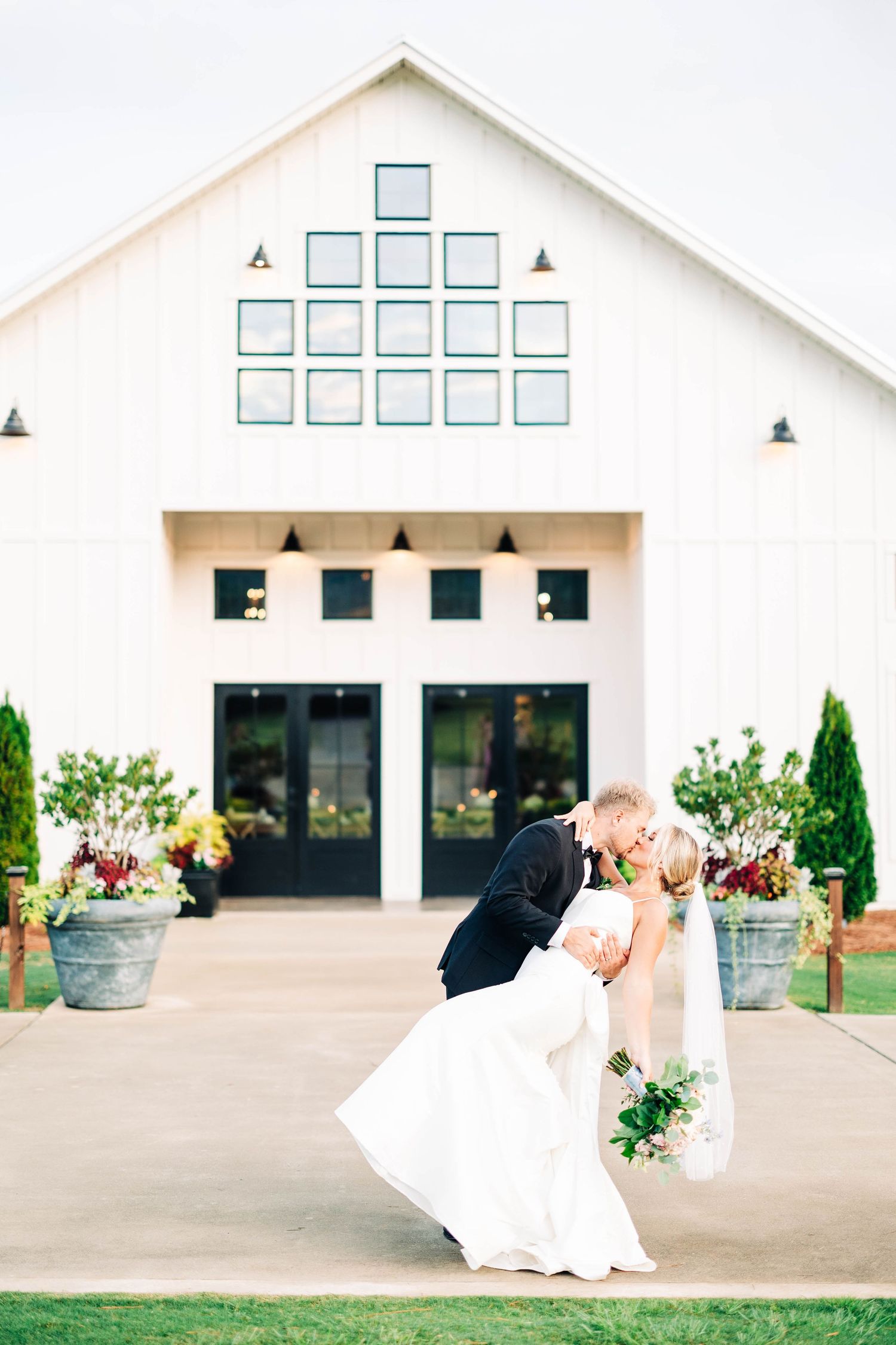 Modern white wedding venue exterior with minimalist architectural design and geometric windows.