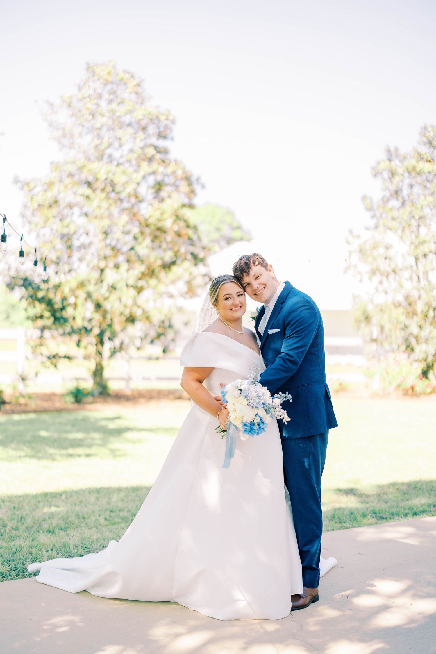 Sunlit outdoor wedding portraits showing intimate moments between newlyweds.
