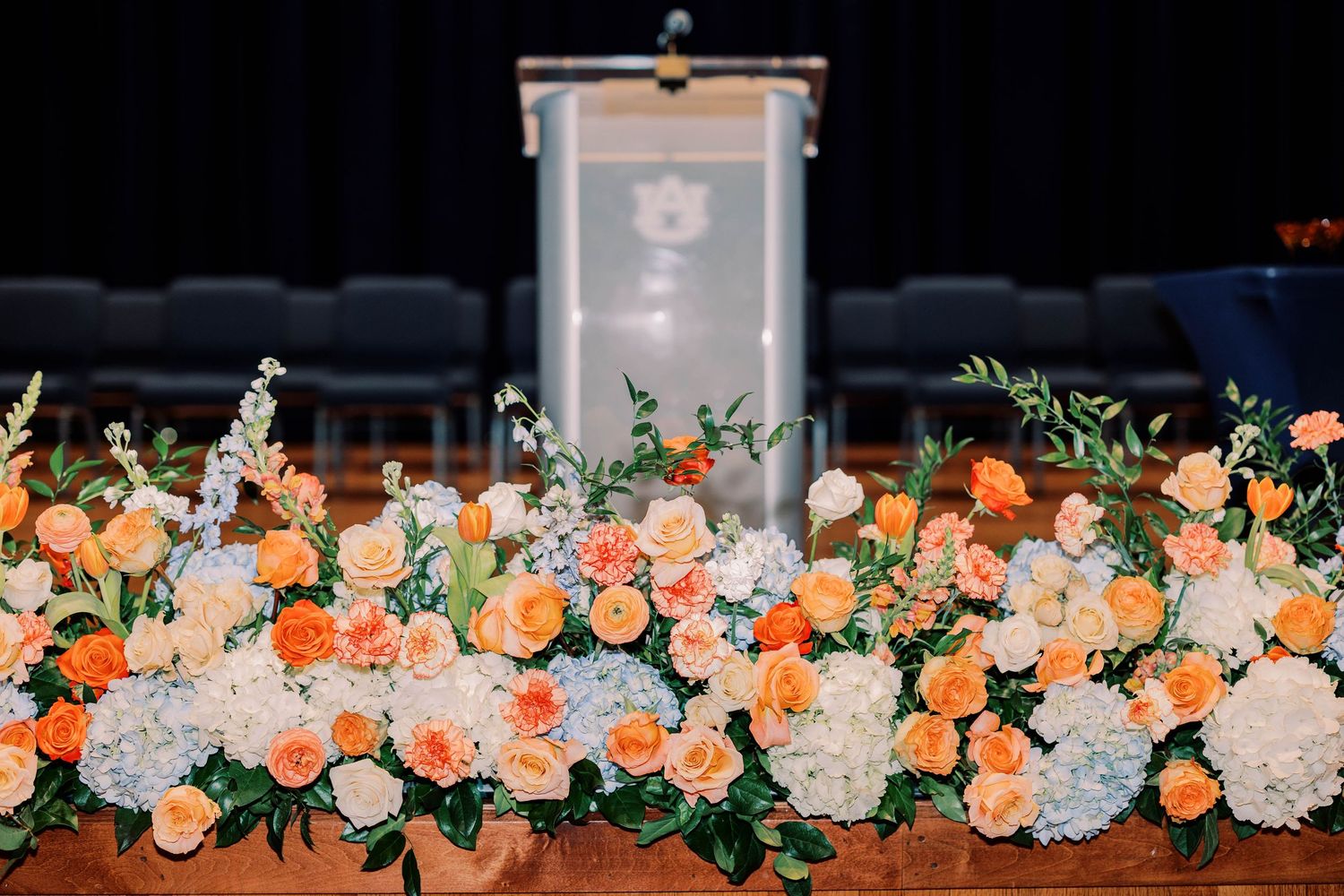 A decorative border of peach and white roses with greenery against a dark background.