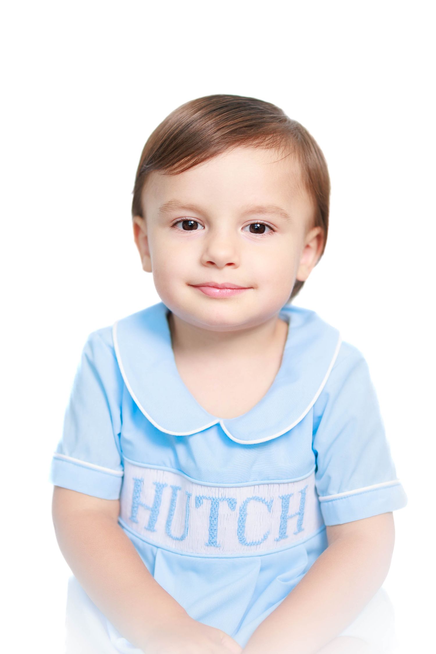 Adorable toddler boy named Hutch posing in a light blue embroidered Peter Pan collar shirt.