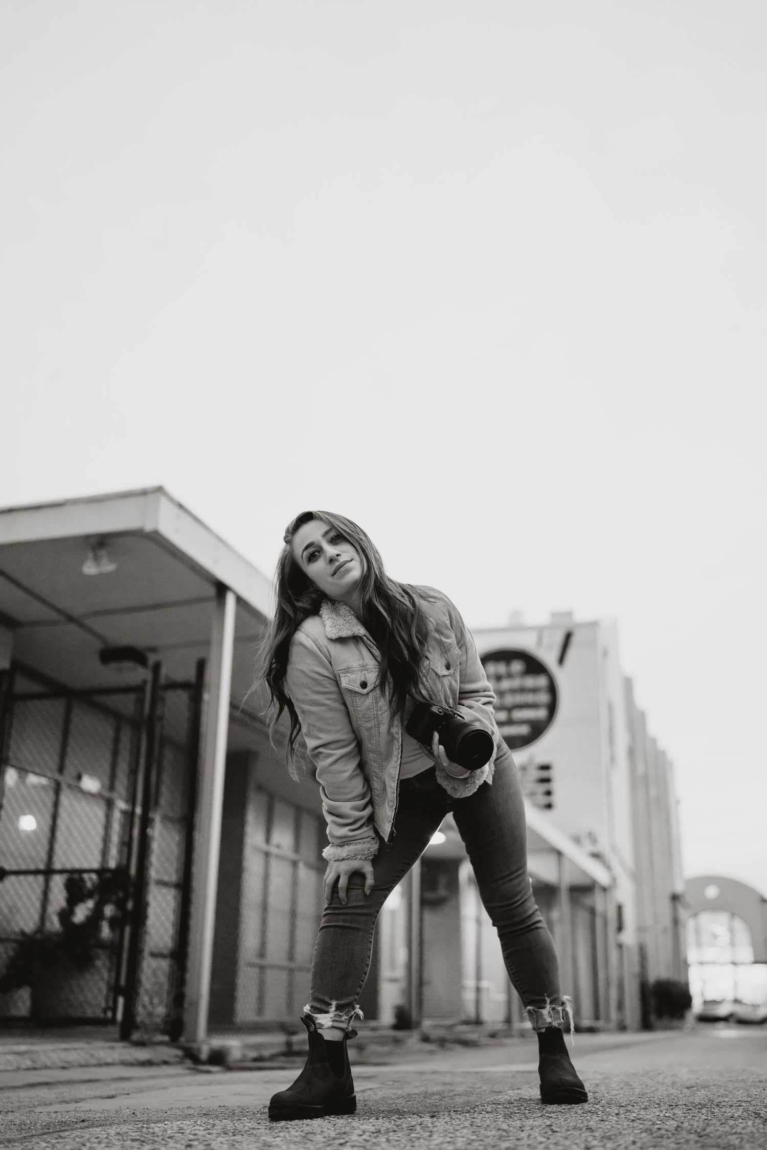 A person in a denim jacket and boots strikes dynamic poses in a series of black and white urban street photos.