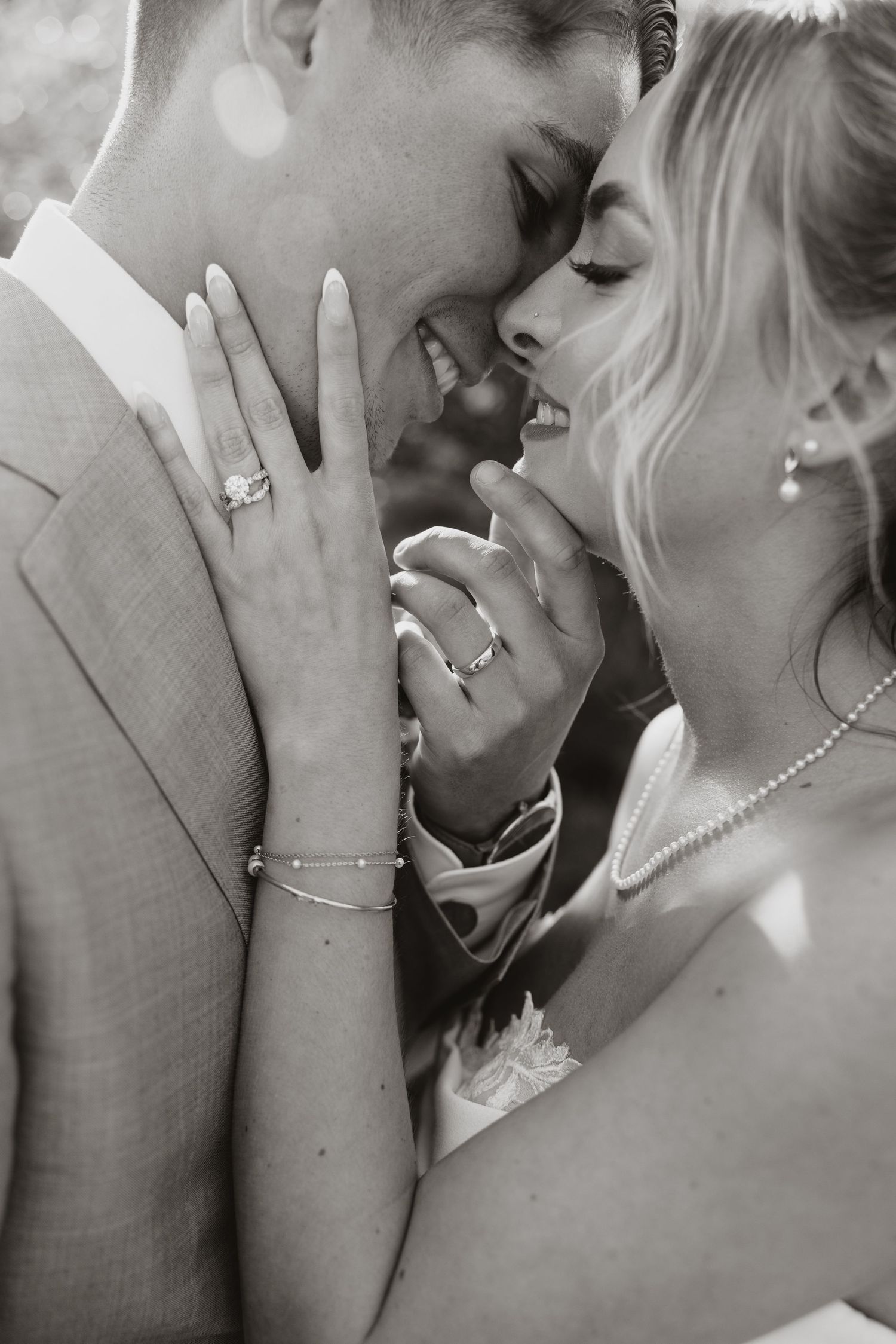 A series of romantic black and white photos showing a couple sharing intimate kisses while wearing wedding attire.