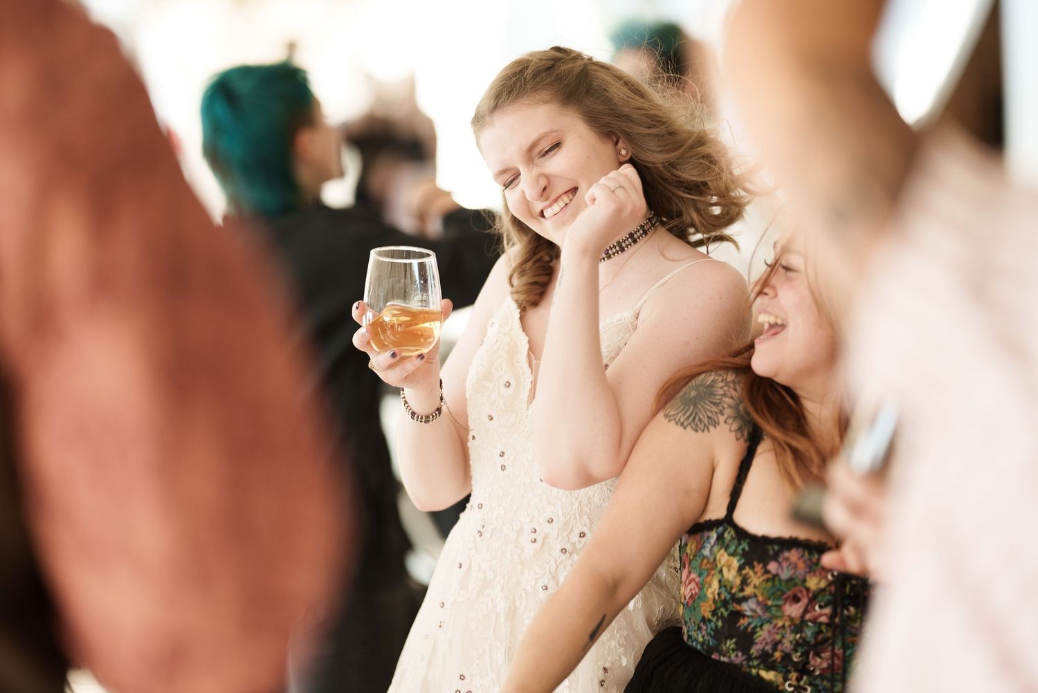 Candid moment of joy at a celebration with champagne glass and laughter.