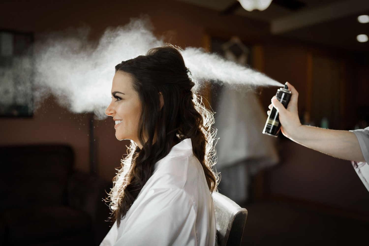 Hairspray creates a backlit effect during wedding day preparations.