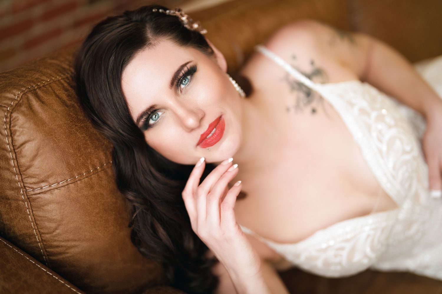 Portrait in white lace against brown leather displaying elegant glamour and romance.