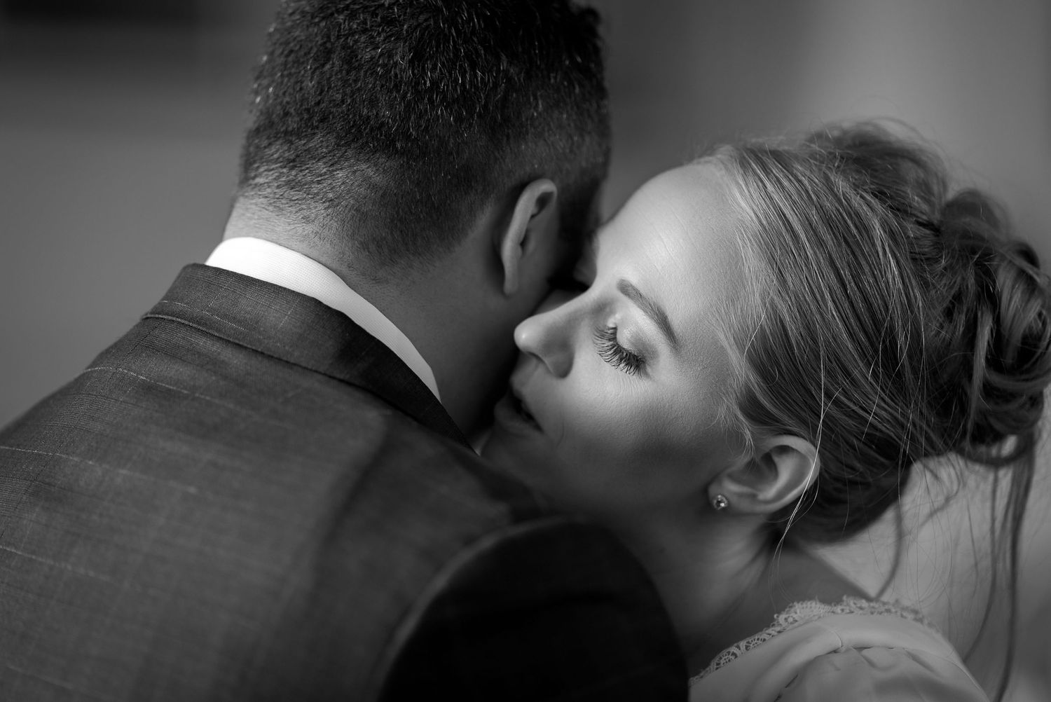 An intimate black and white portrait of a tender wedding day embrace.