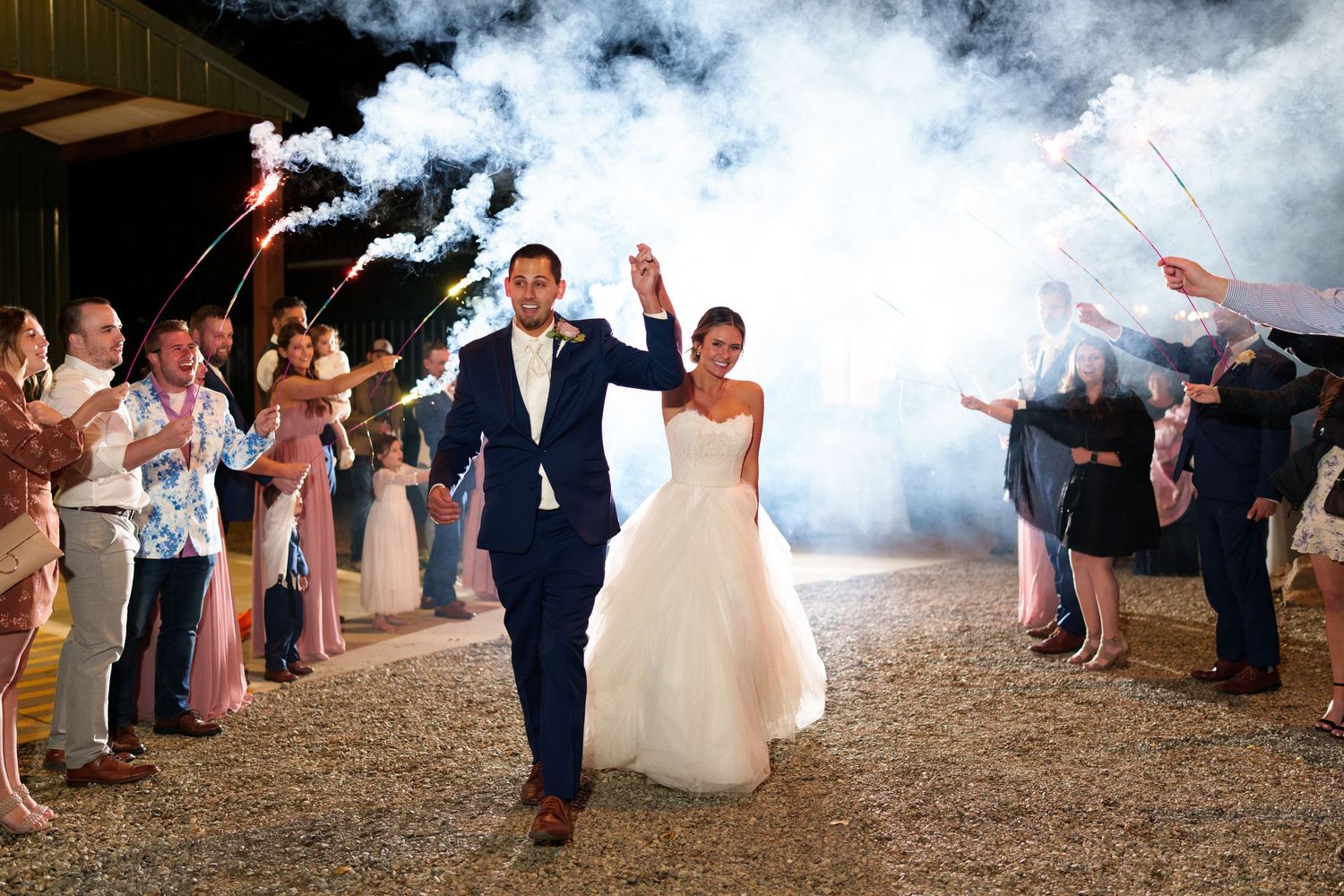 Wedding celebration exit with smoke effects and sparklers creating a magical atmosphere.