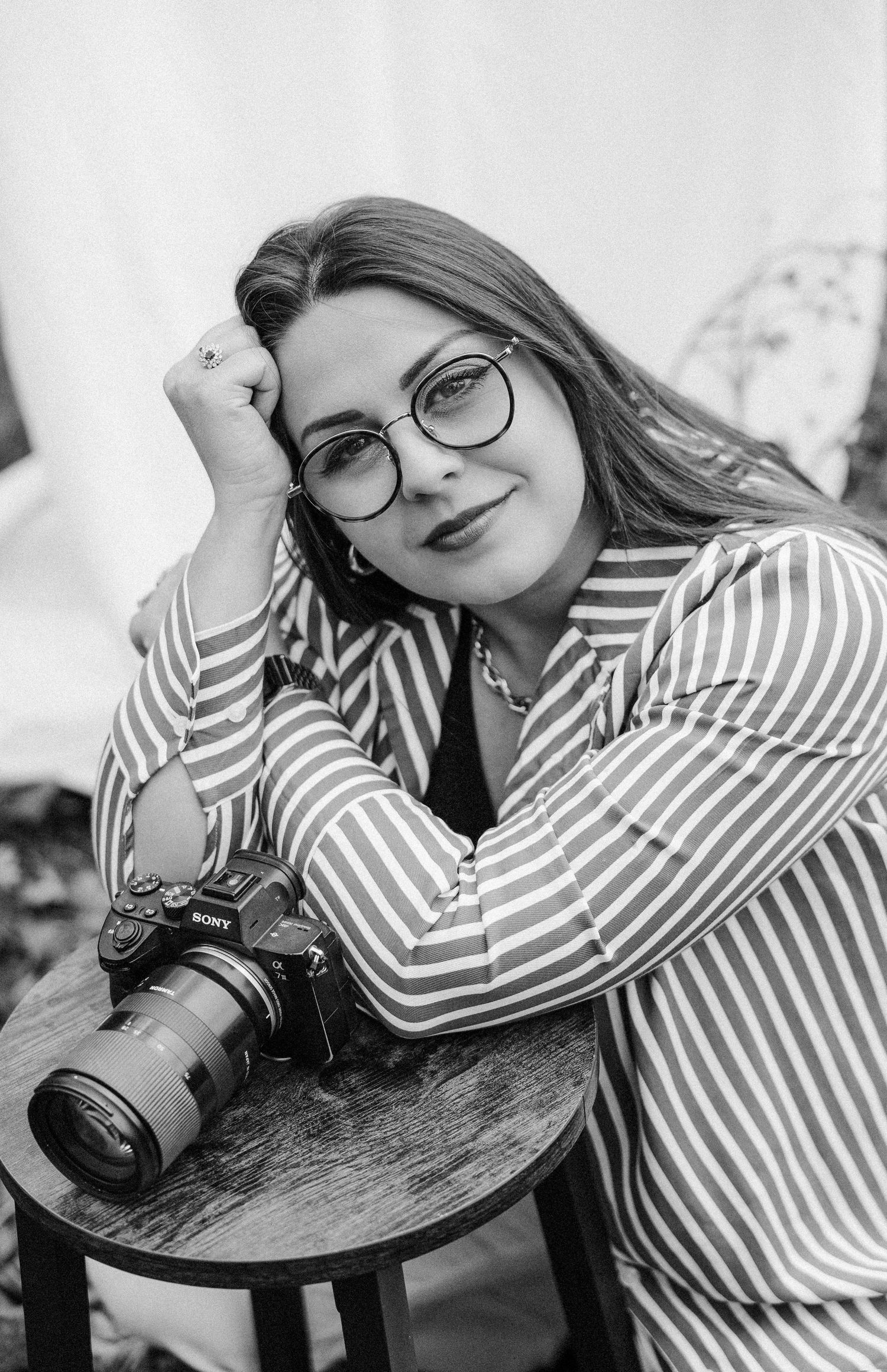 Black and white portrait series showing a photographer with a camera in striped shirt.