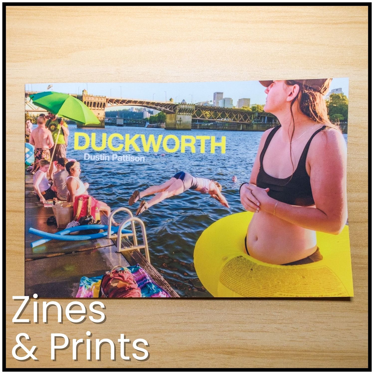 People enjoying summer activities at a waterfront dock with yellow floats and swimming areas.