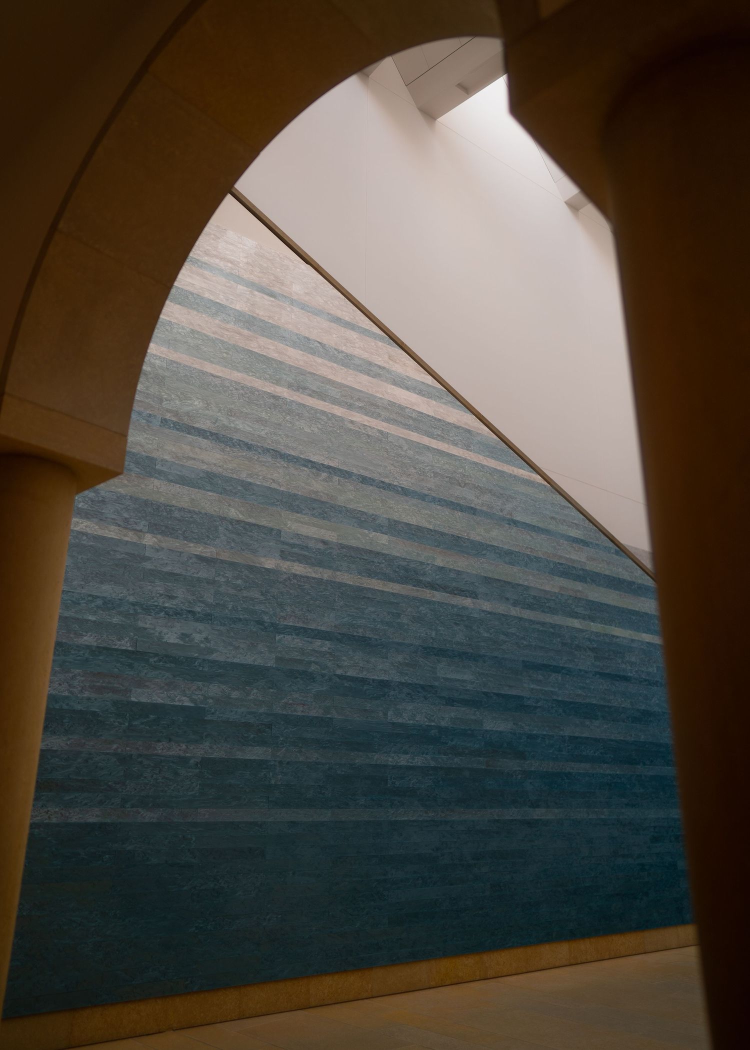 Modern architectural detail showing curved arches and gradient blue wall pattern.
