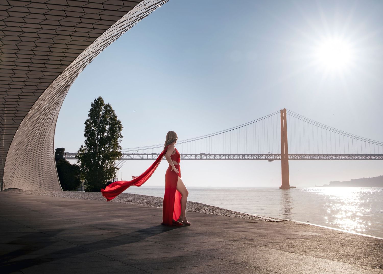Minimalist architectural curve with red accent against bright sky.