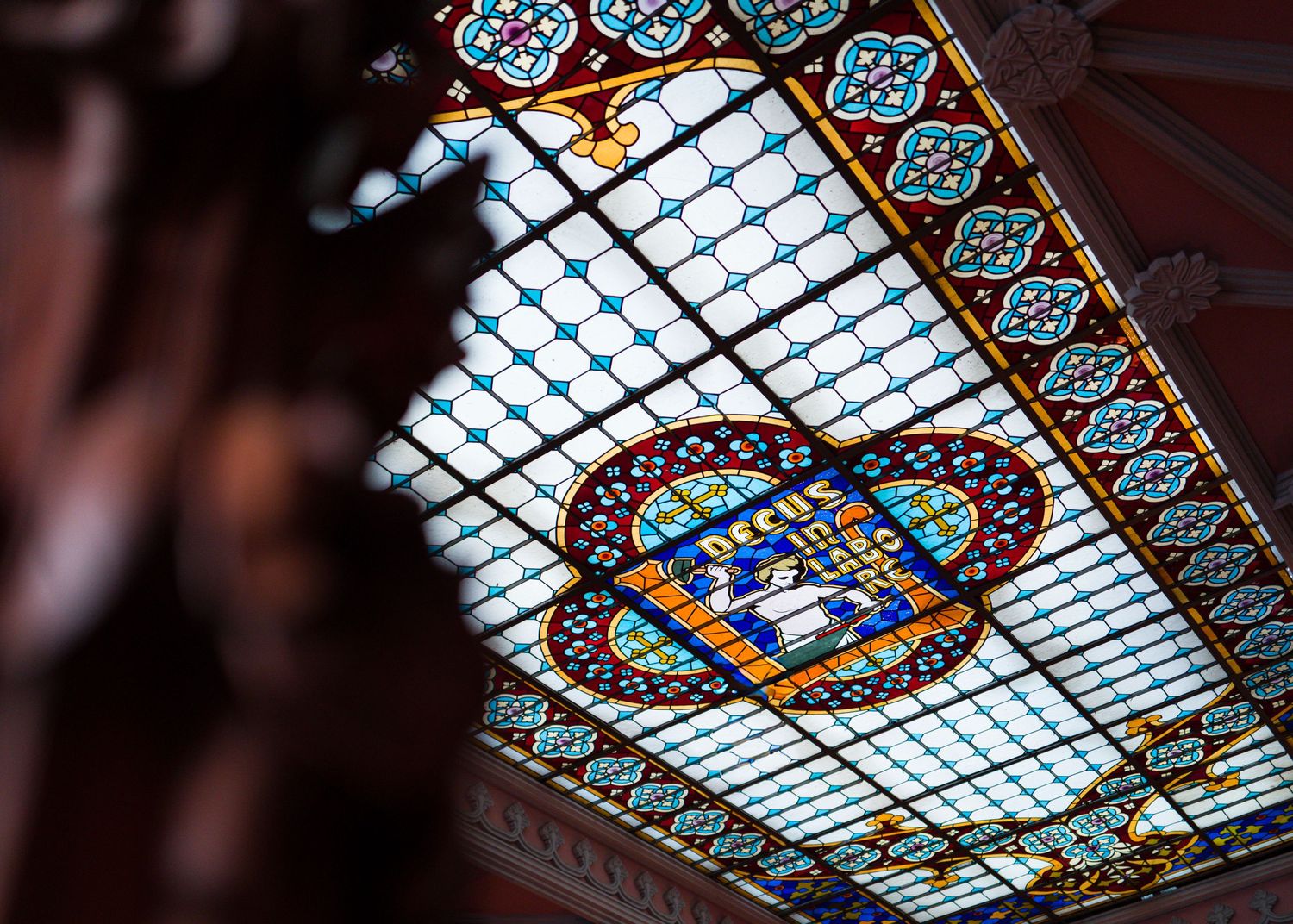 Colorful stained glass ceiling with intricate floral and geometric patterns.