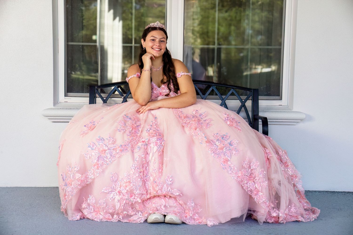 Outdoor portrait series featuring pink lace dress against white building.
