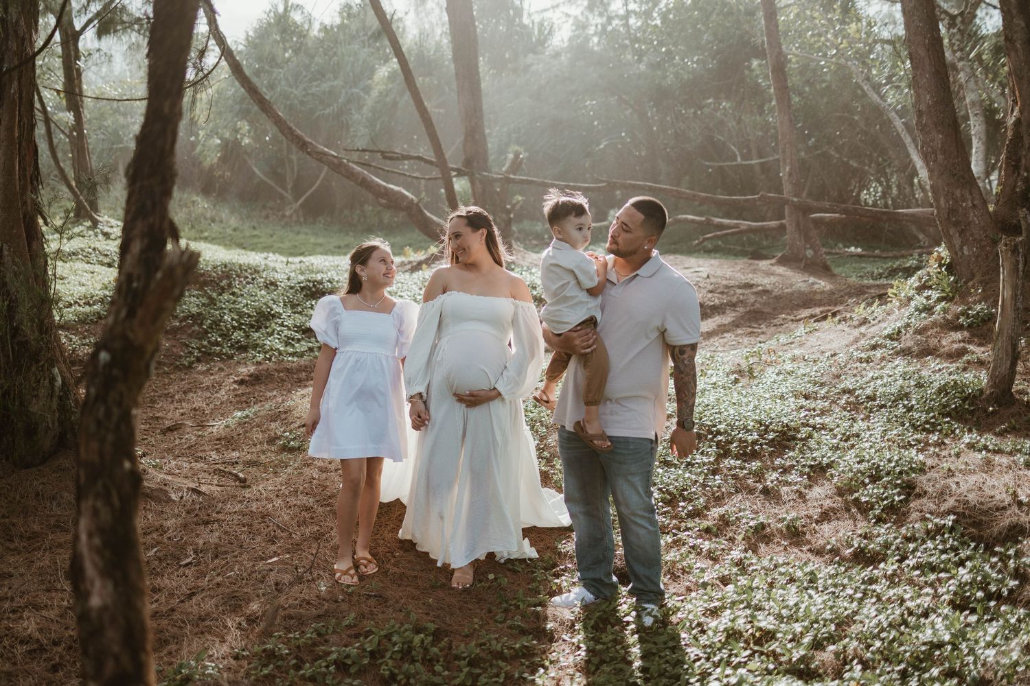 A family enjoys a casual stroll through a misty wooded area during a photo session.