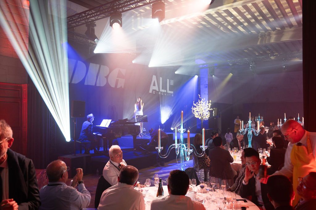 Échanges entre convives autour d’une table de gala dans un événement d’entreprise haut de gamme.