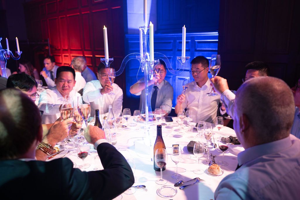 Toast entre dirigeants autour d’une table de gala au château de Chambord, ambiance festive et élégante.