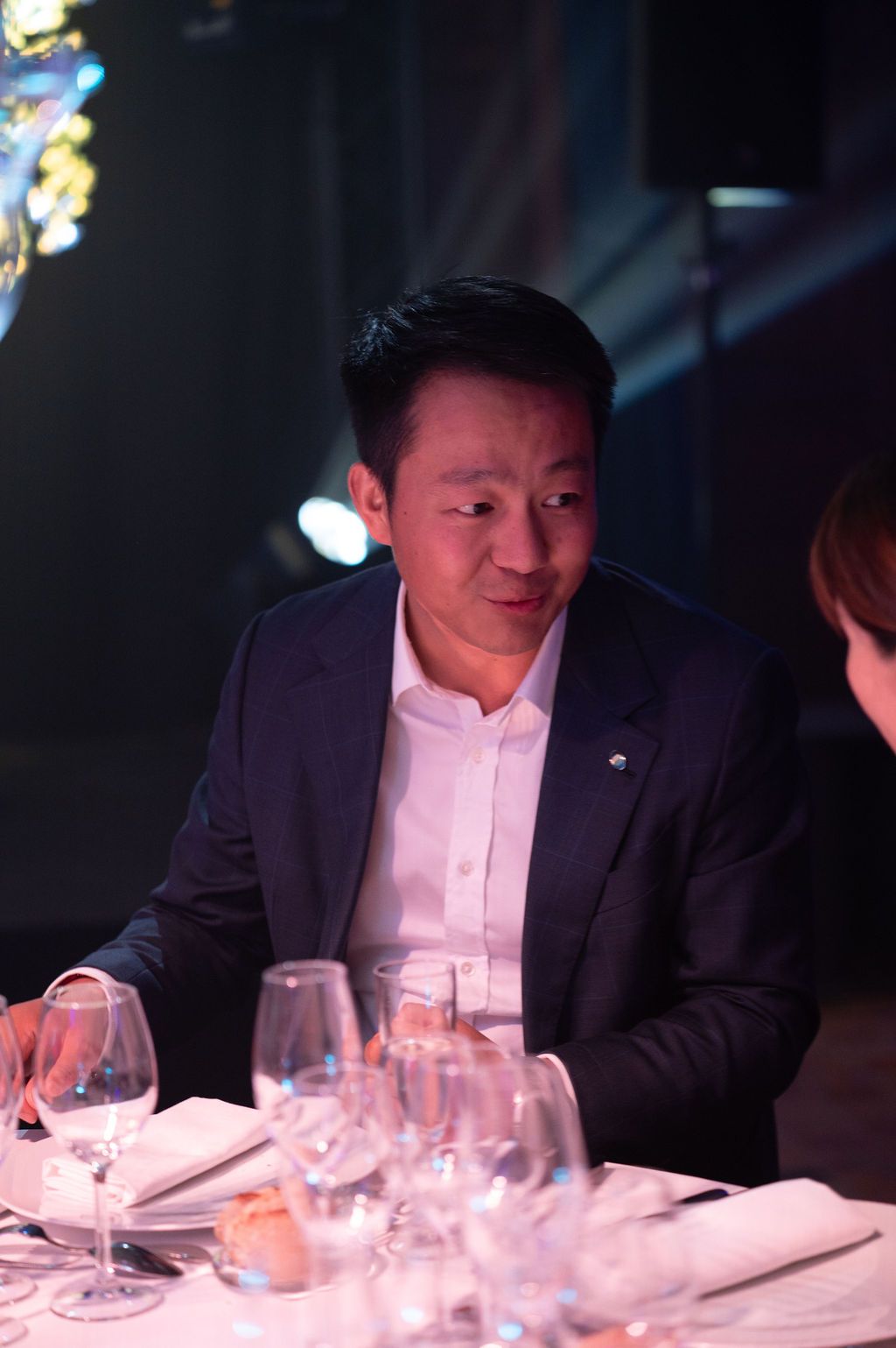 Un invité échange à table dans l’ambiance feutrée du dîner d’entreprise.
