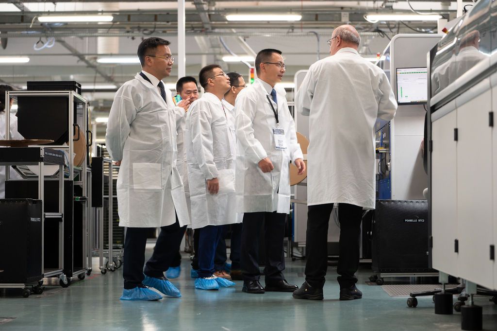 Reportage corporate : dirigeants internationaux visitant ligne  SMT d’une entreprise électronique — visuel premium  B2B, Loiret  45