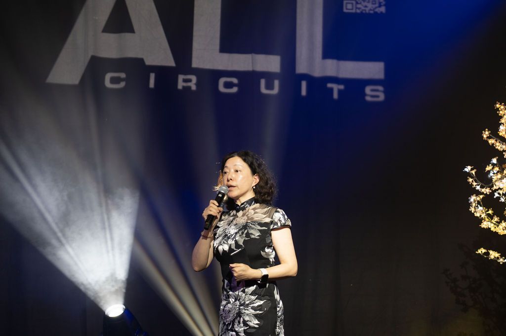 Une intervenante s'exprime sur scène devant les invités d’un gala professionnel.