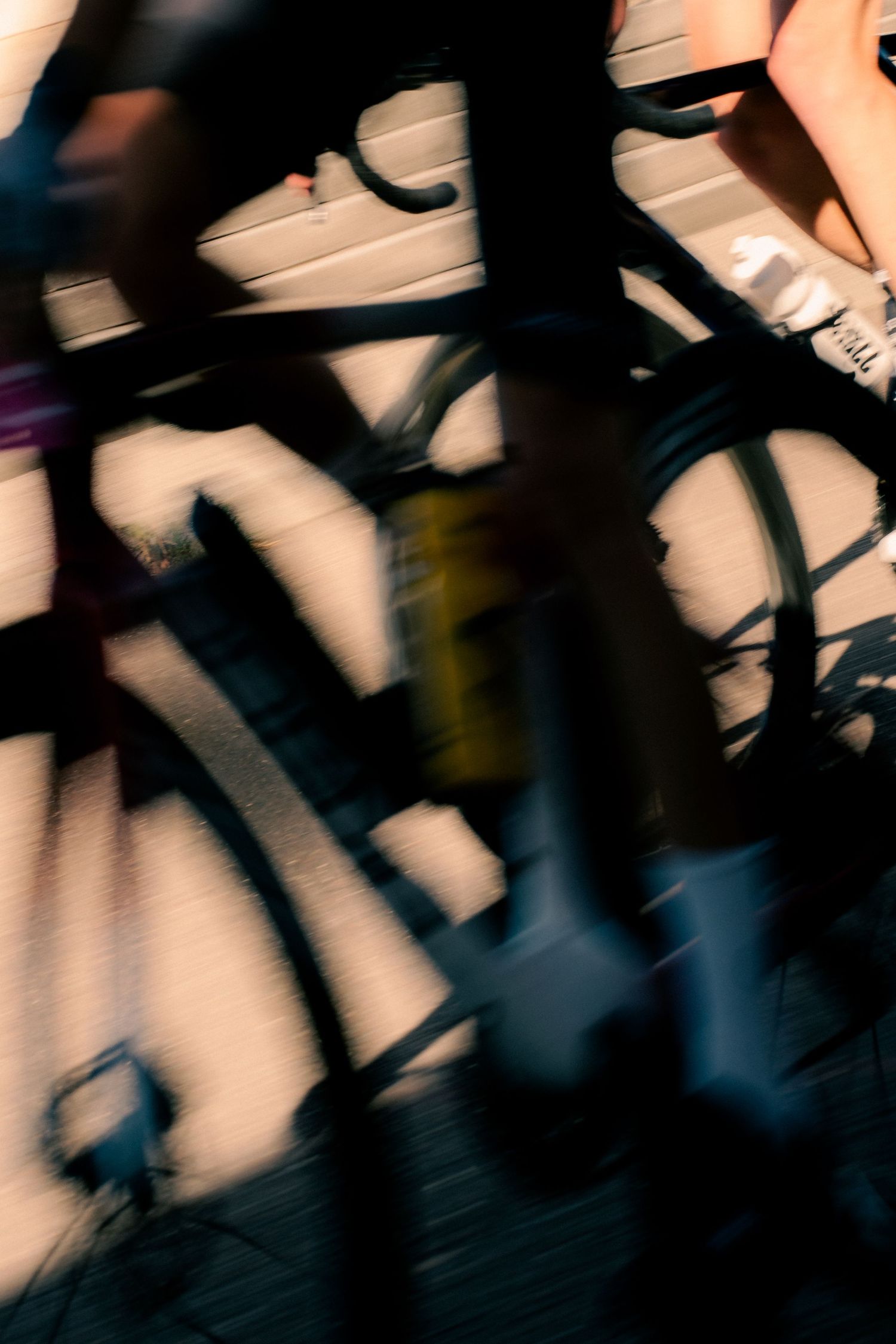 Blurred motion shot of a cyclist racing past ornate iron railings, capturing speed and movement in dramatic light.