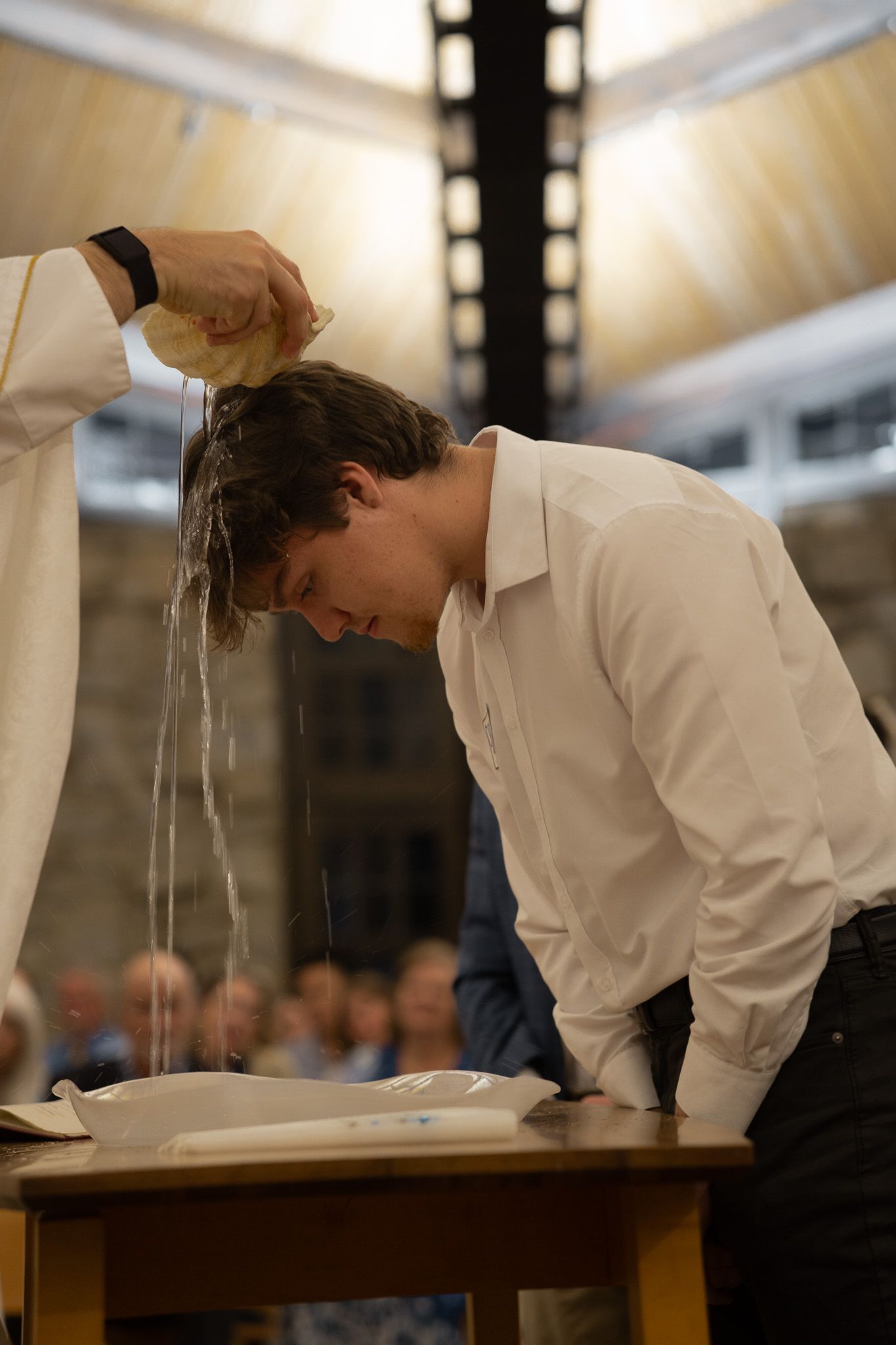 Young man being baptized with water poured over his head during a Catholic Easter Vigil Mass in Athens, GA.