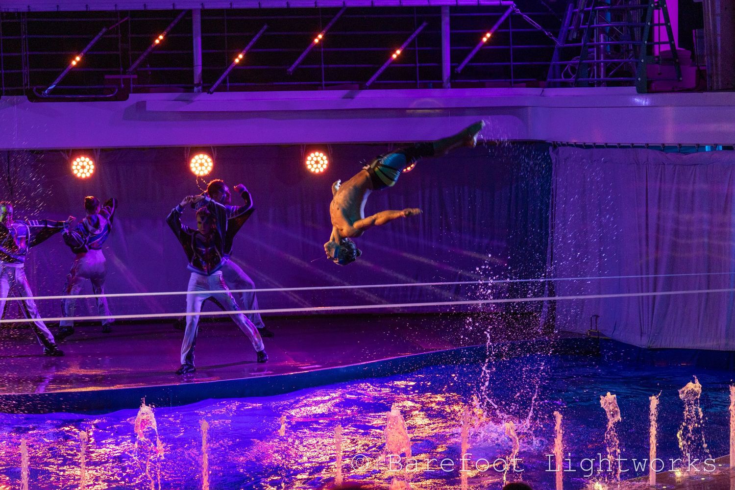 A photo of an impressive performer from a cruise ship doing a backflip on a slackline