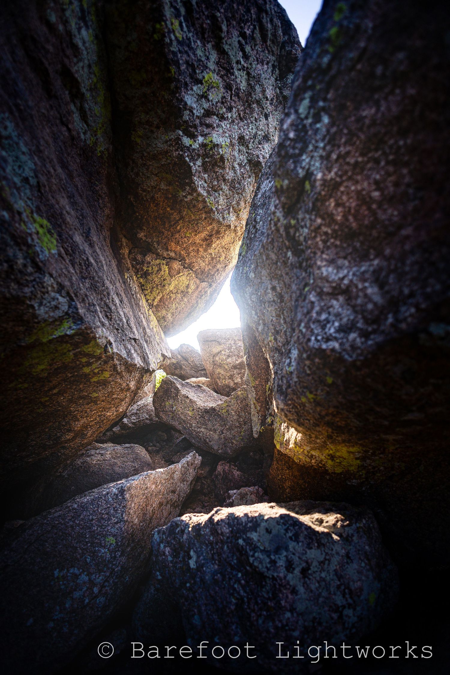 A photo at Arthur's rock in Colorado where the morning light shines through a few crevasses in the rock and stacked stone creating gorgeous