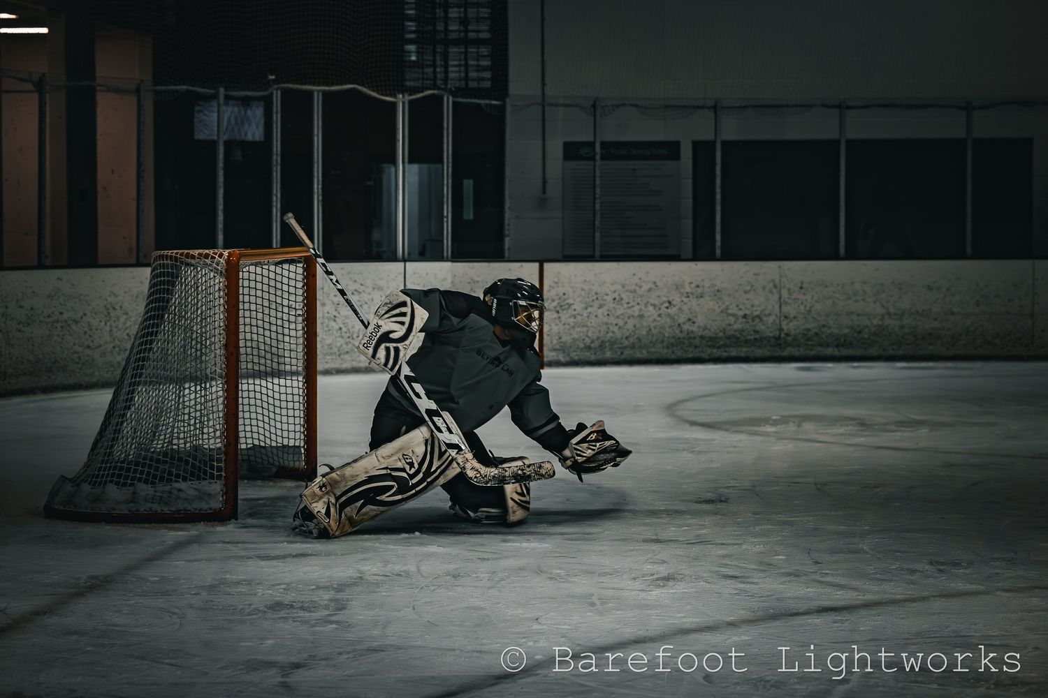 A sports photography photo of a hockey player, goalie, grungy look, dark and gritty.