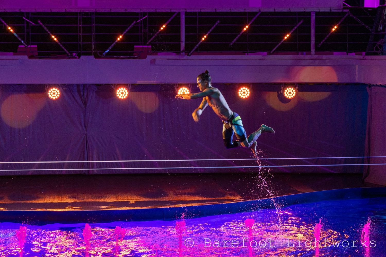 A photo of an impressive performer from a cruise ship doing a trick on a slackline