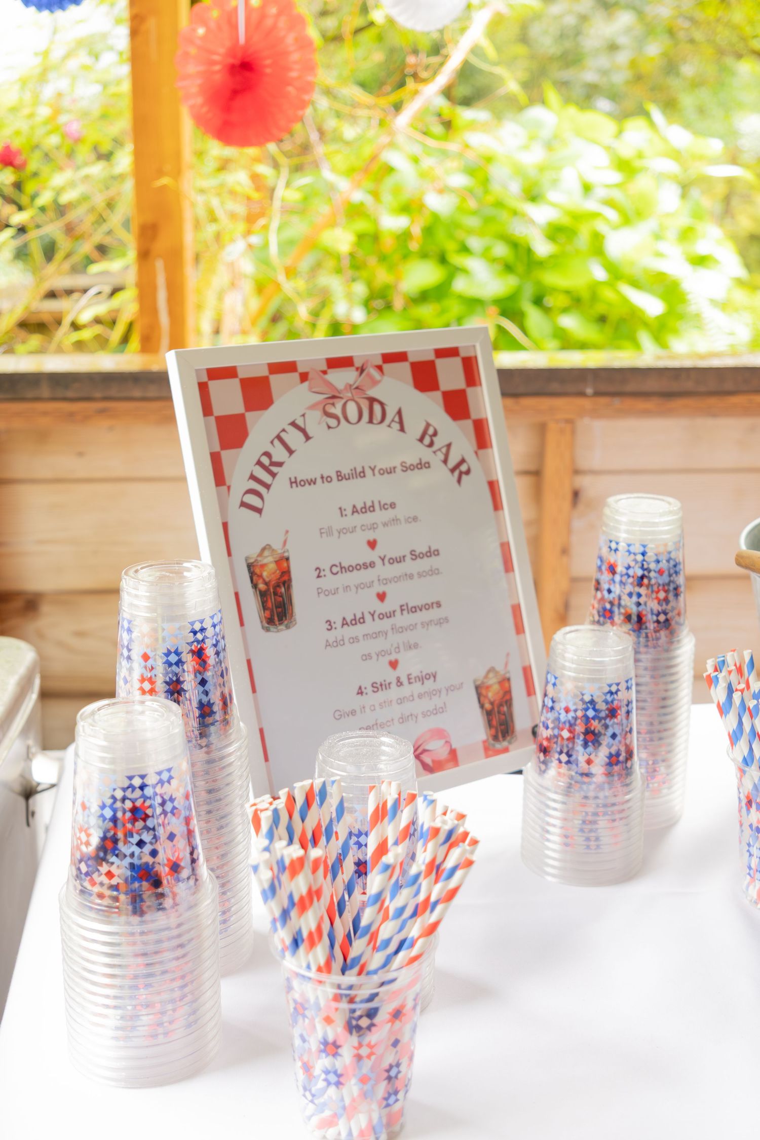 Dirty Soda Bar setup with cups, colorful straws, and instructions sign at party.