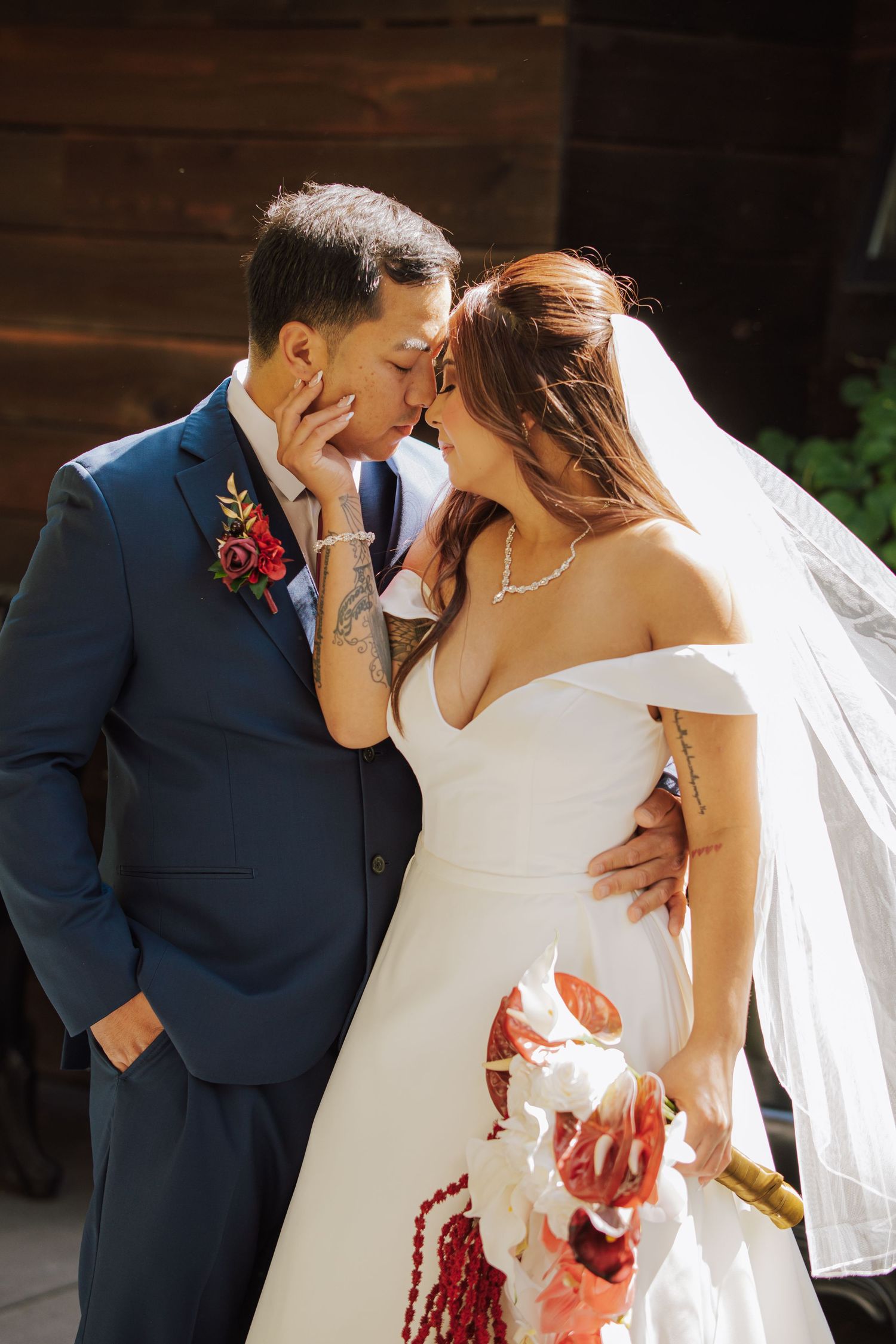 Bride and groom sharing a romantic kiss outdoors on their wedding day.