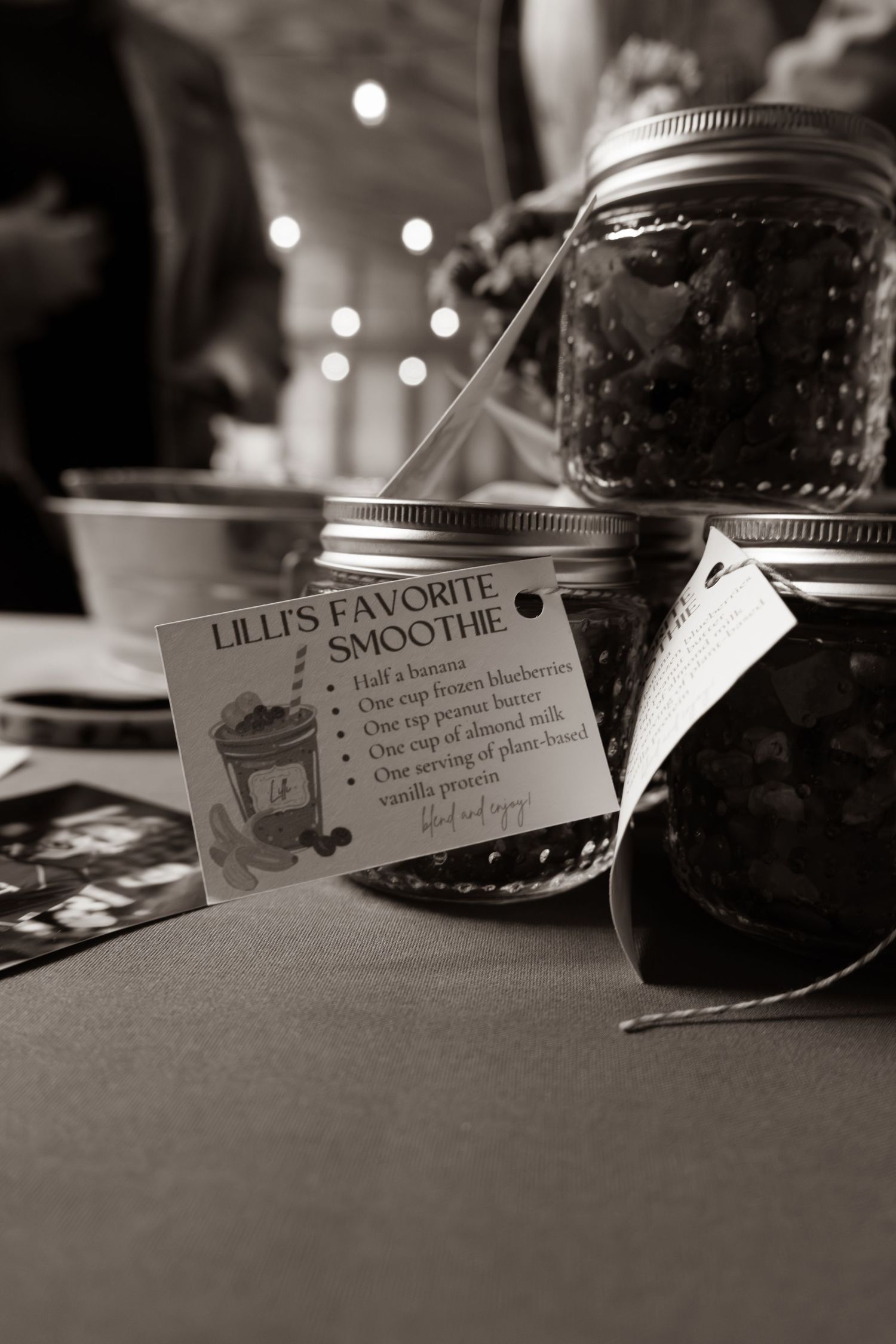 Black and white photo of mason jars with Lilli's Favorite Smoothie recipe card at party table.