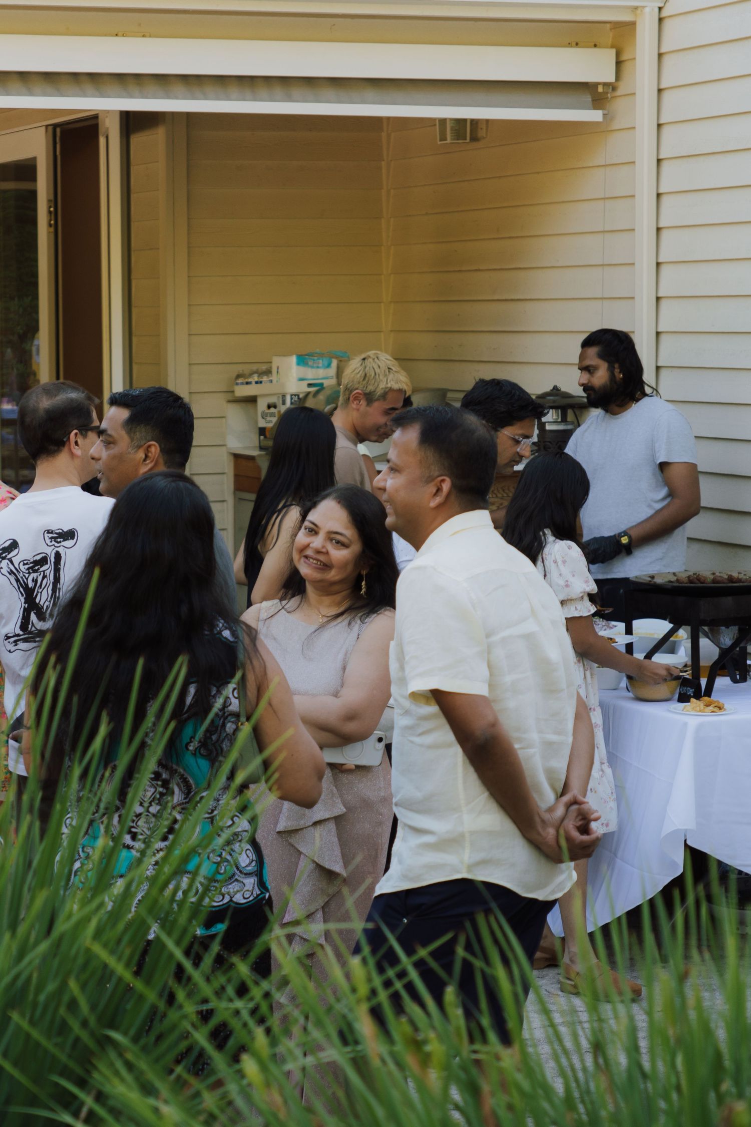 Guests mingling and socializing at an outdoor backyard graduation celebration party.