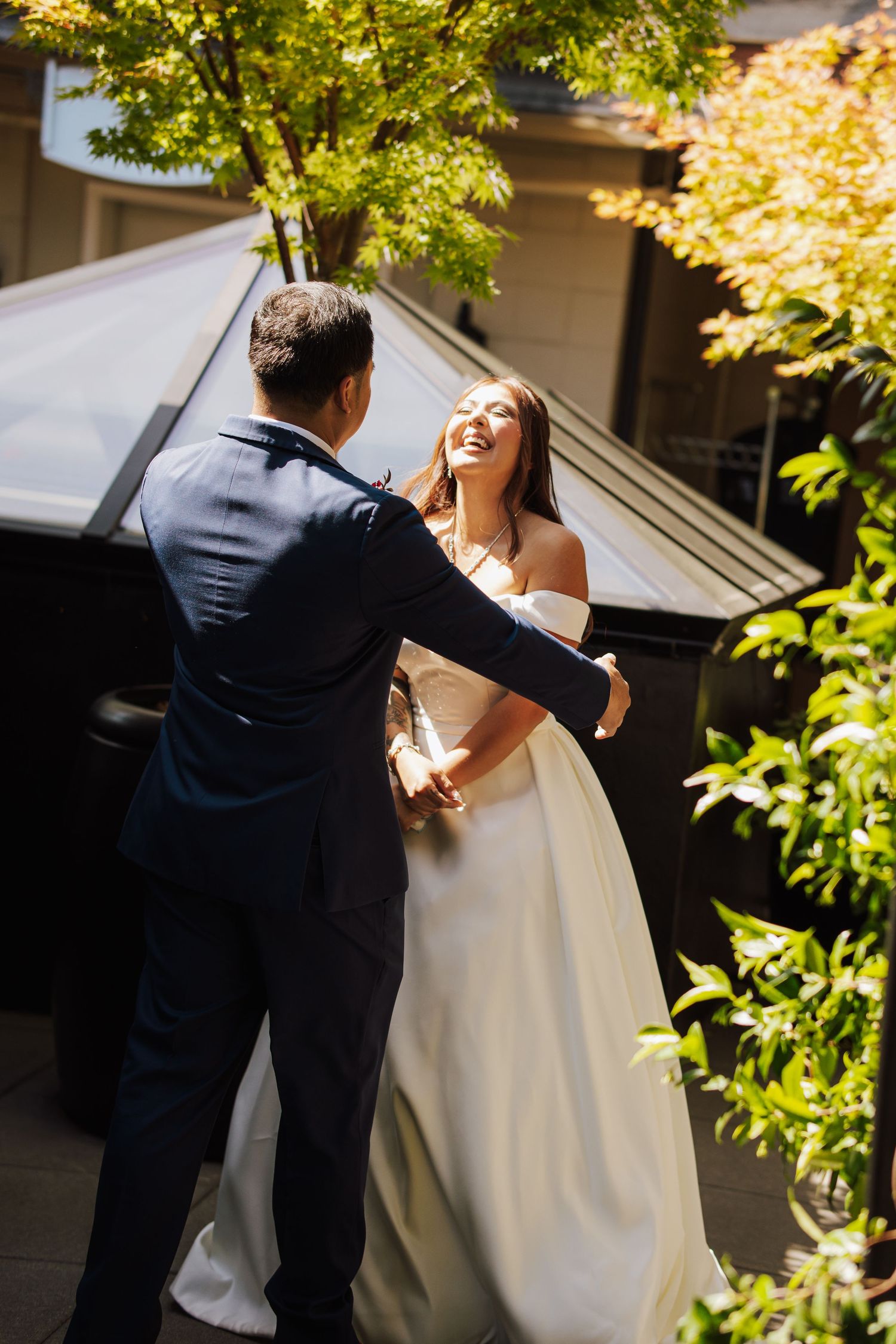 Bride and groom sharing a joyful first look moment outdoors surrounded by autumn trees.
