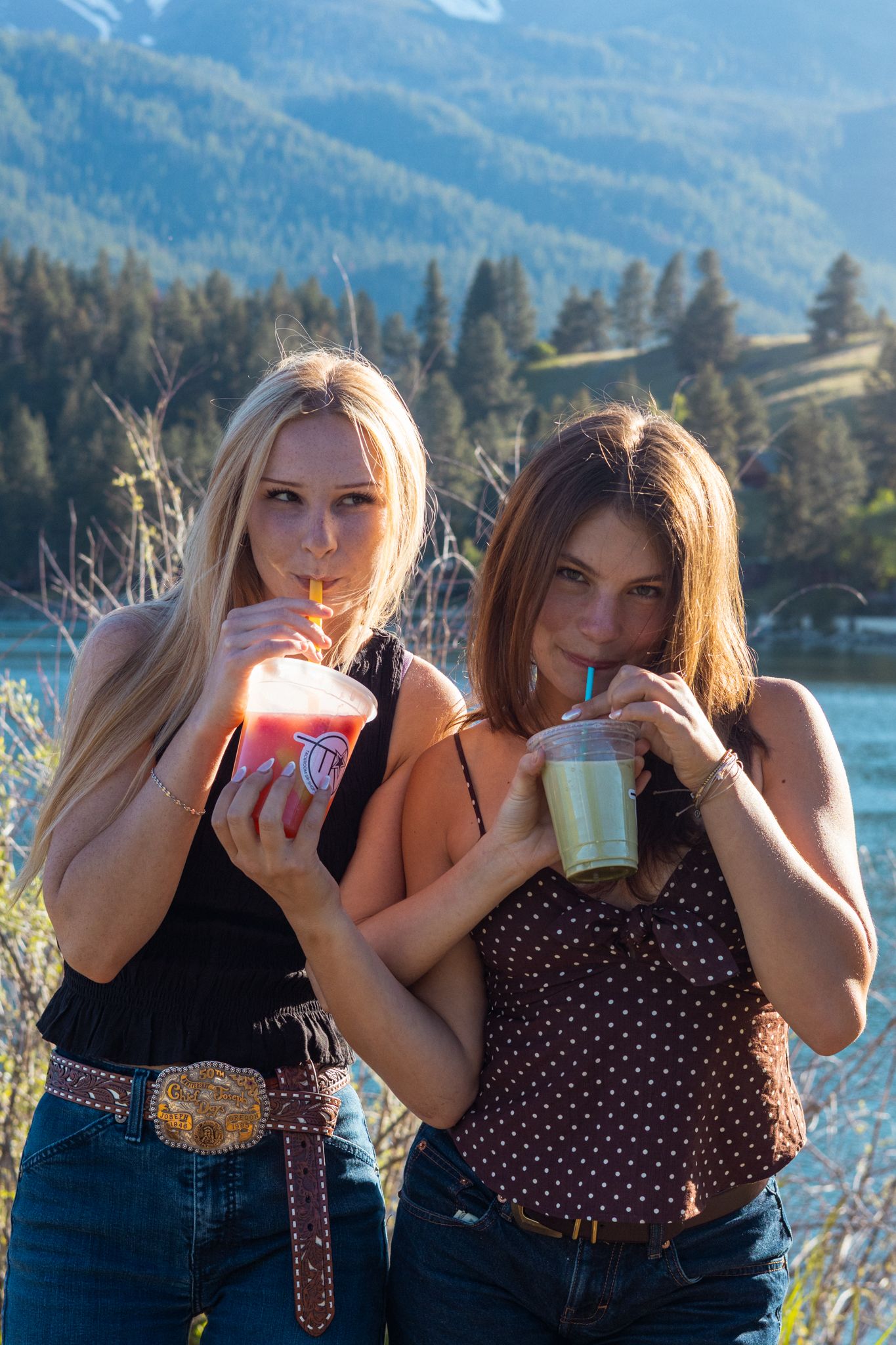 Two girls laugh and share a drink in this coffee photoshoot in the mountains.