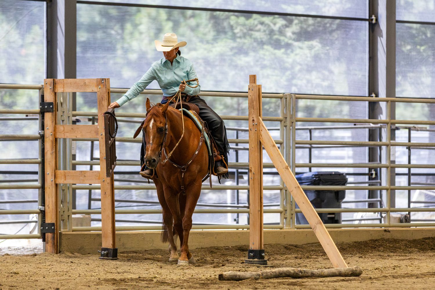 Horse show photography coverage where a woman completes the gate at a ranch trail class.