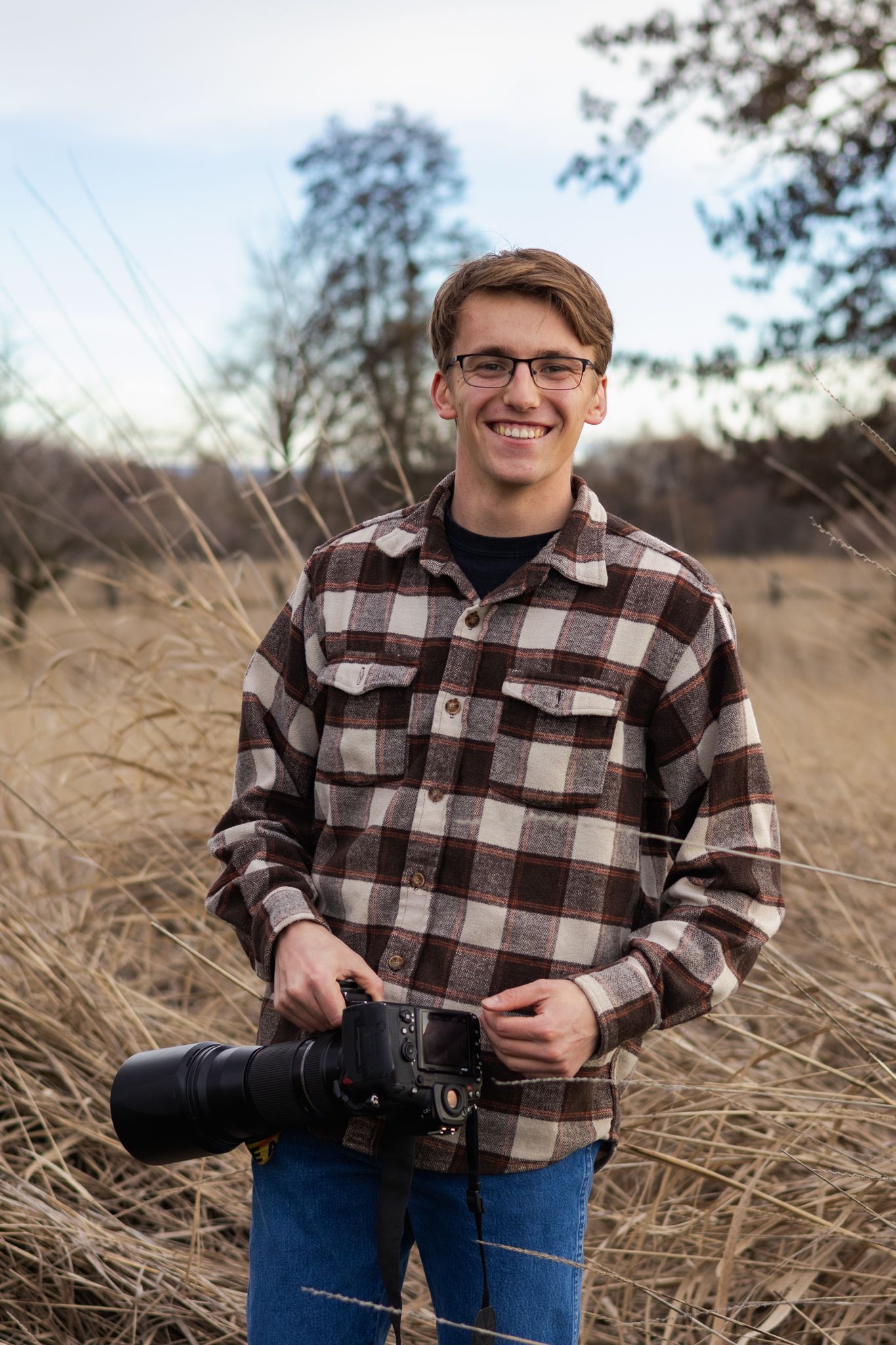 Gabe Watson an acclaimed bird and wildlife photographer poses with his camera for this outdoor branding photoshoot.