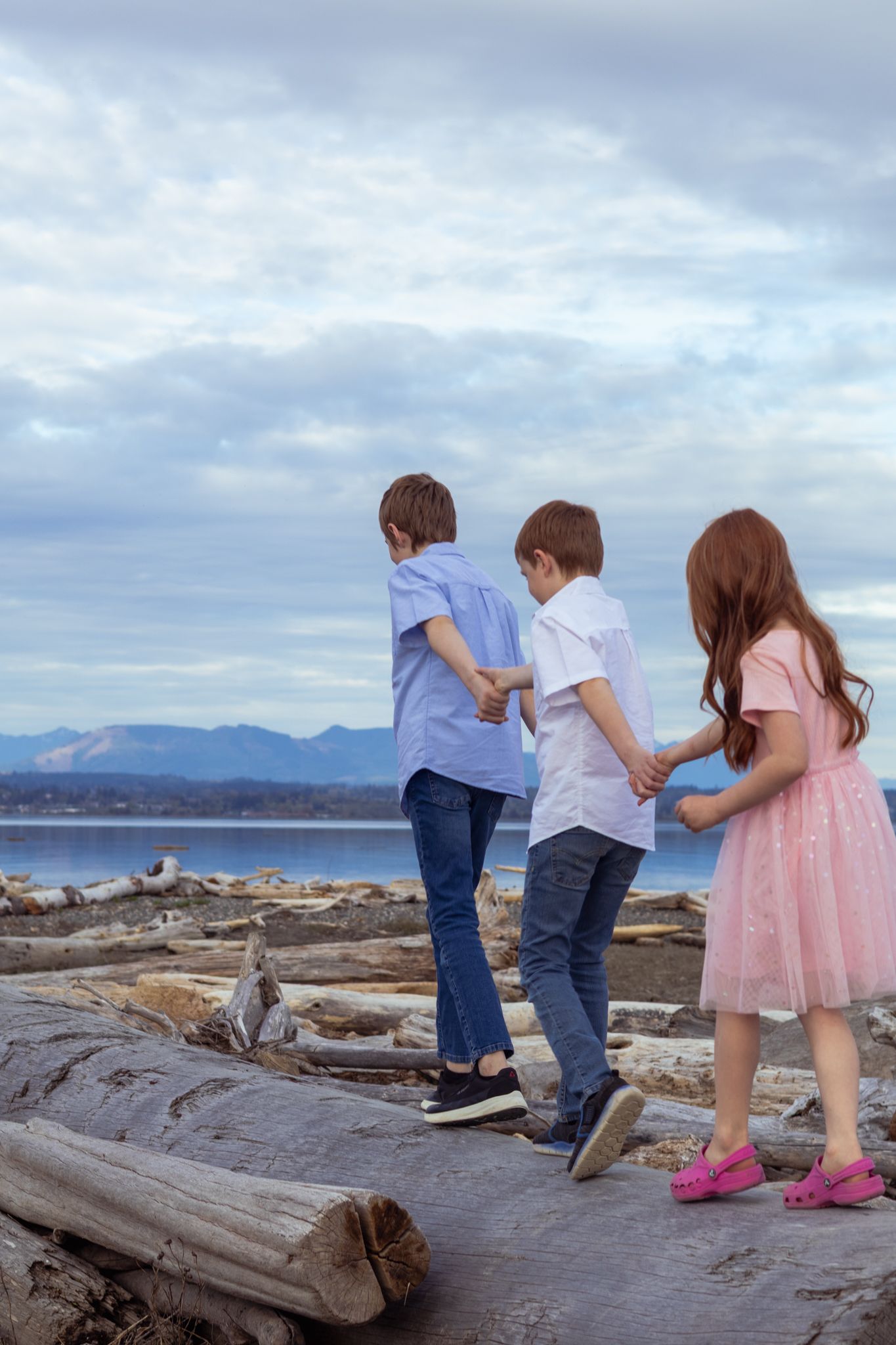 three red headed children walk hand in hand in this family photoshoot at Iverson Beach.