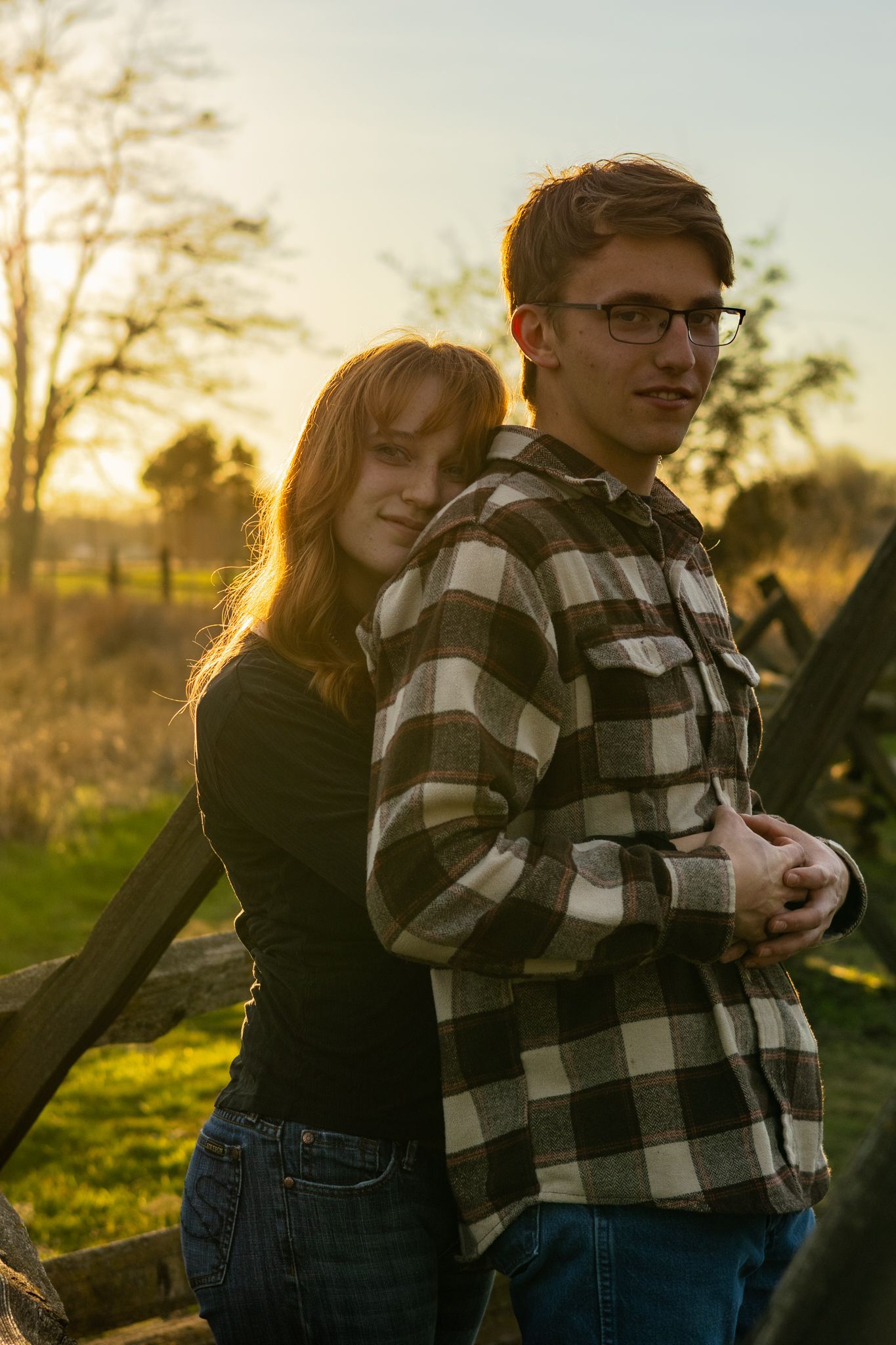 Young couple lovingly embrace each other in an outdoor photo session at Whitman Mission.