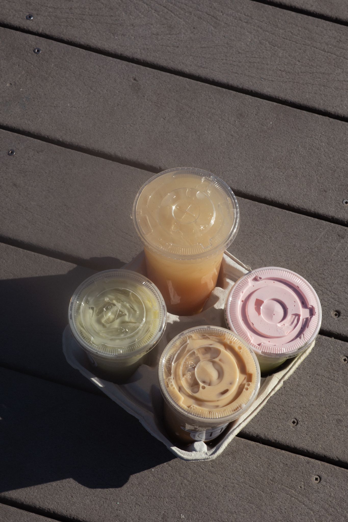 A group of four drinks sits on a lake dock.