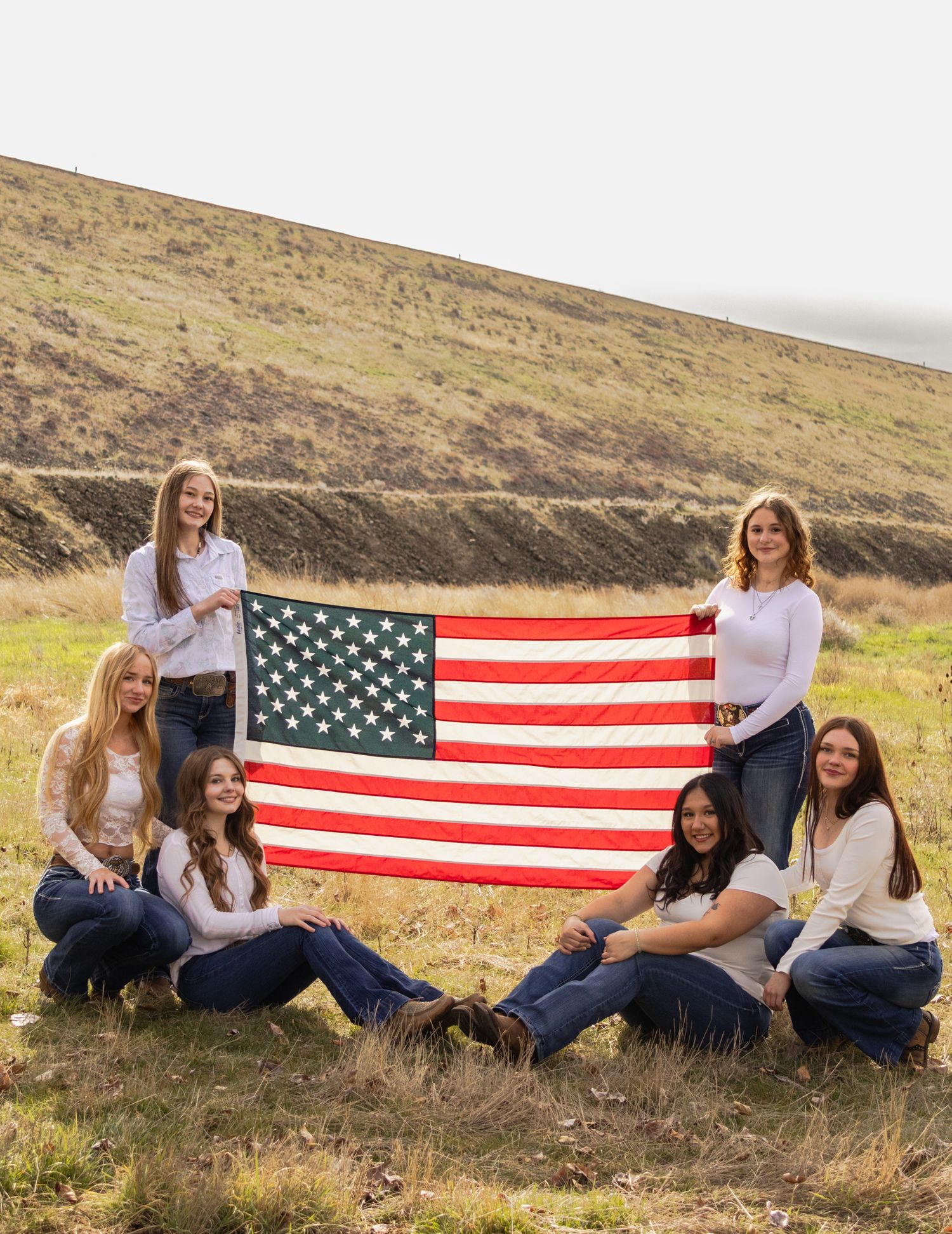 A group of six senior girls pose with their American pride and flag.