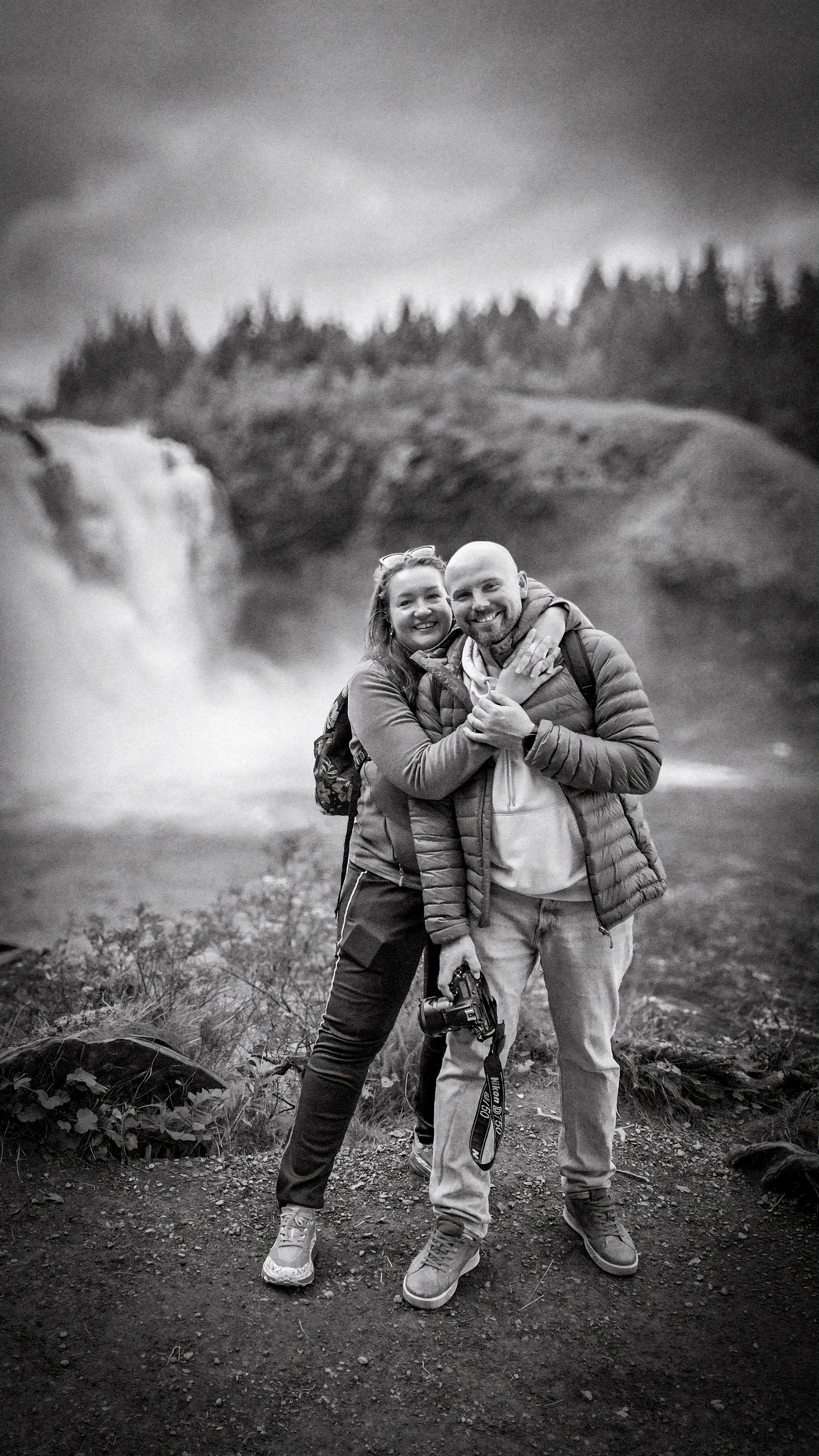 Svart-hvitt parfoto i mektig natur ved foss. Fotograf for bryllup, par og event i Stjørdal, Namsos, Verdal og hele Trøndelag. Book nå!