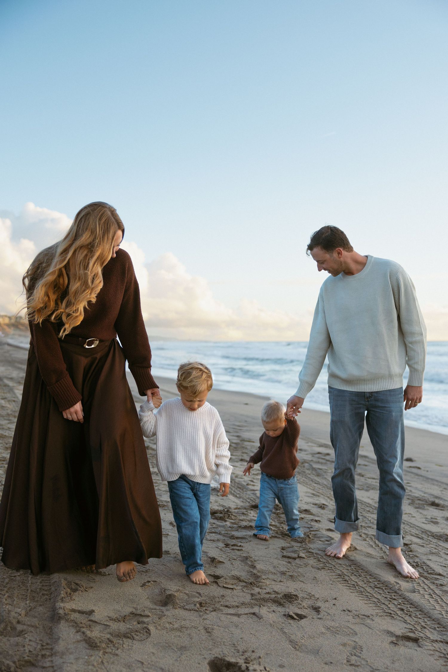 family holding hands at the beach