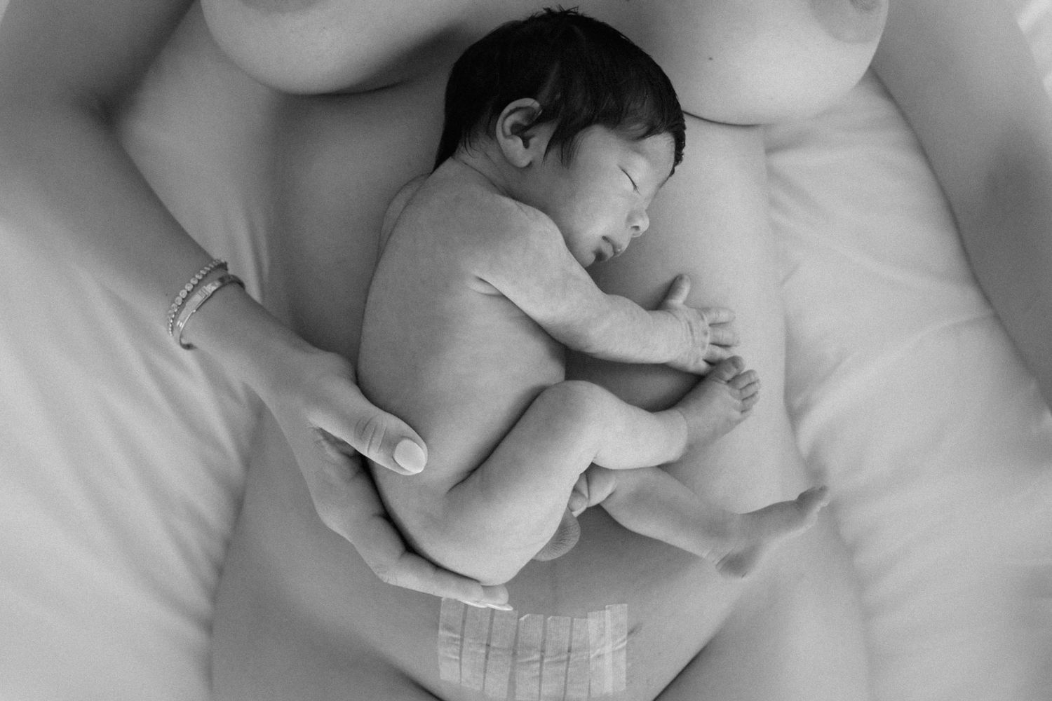Newborn laying on mother