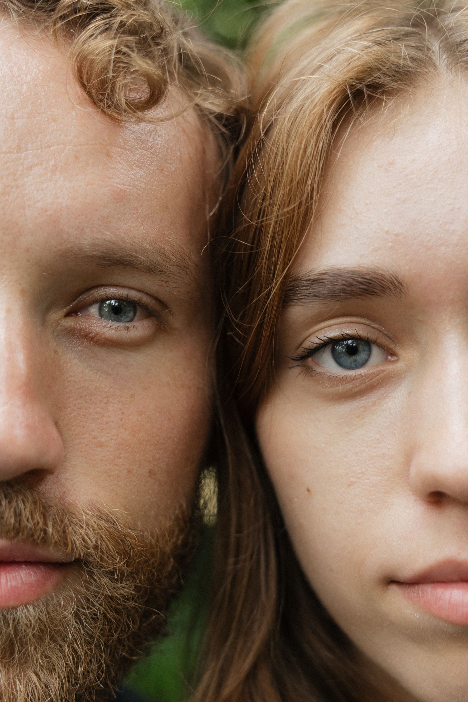 Close-up portrait of a bearded man and young woman with blue eyes and auburn hair side by side.