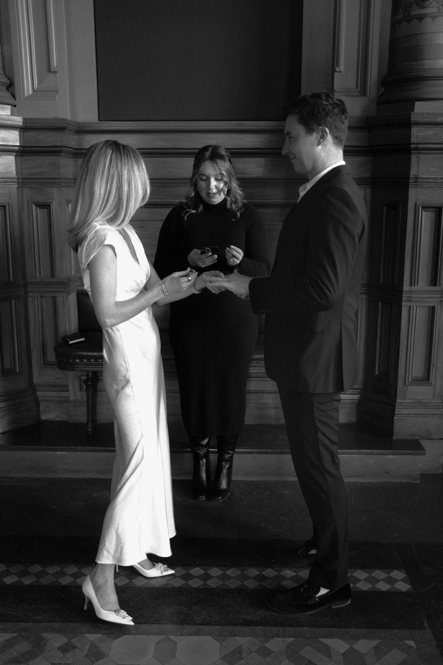 Officiant presiding over intimate civil wedding ceremony between couple in elegant hall.film-inspired