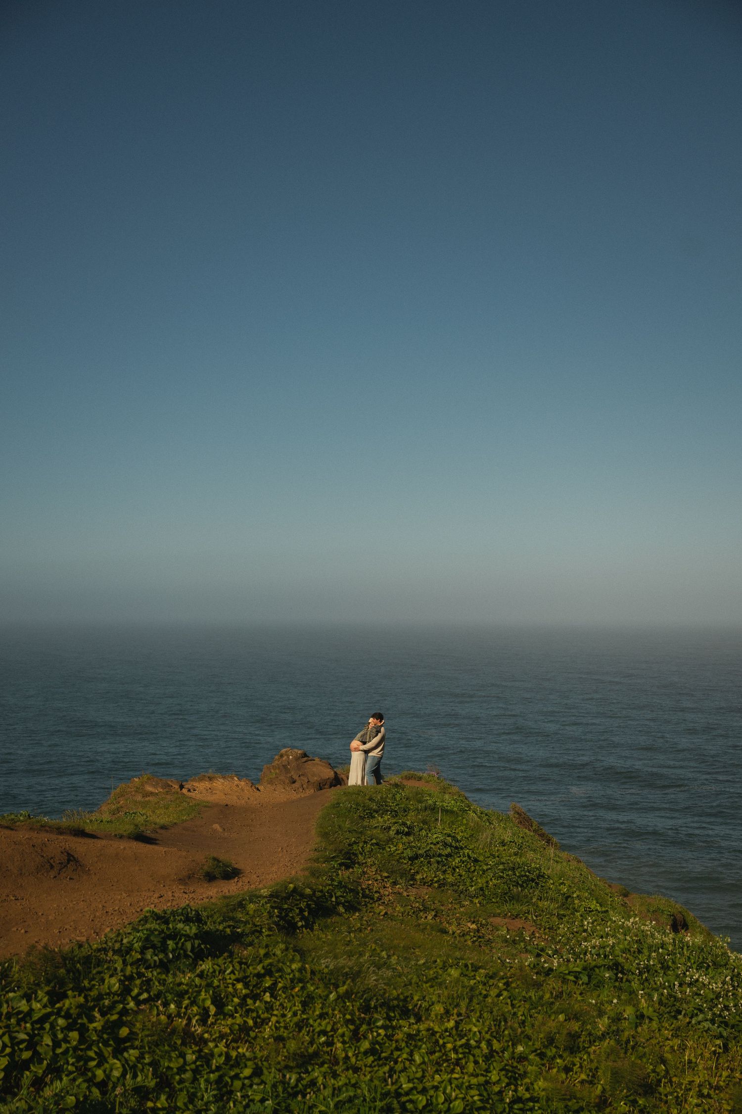Couple in Oregon embrace at the Elk Flats for a maternity photoshoot